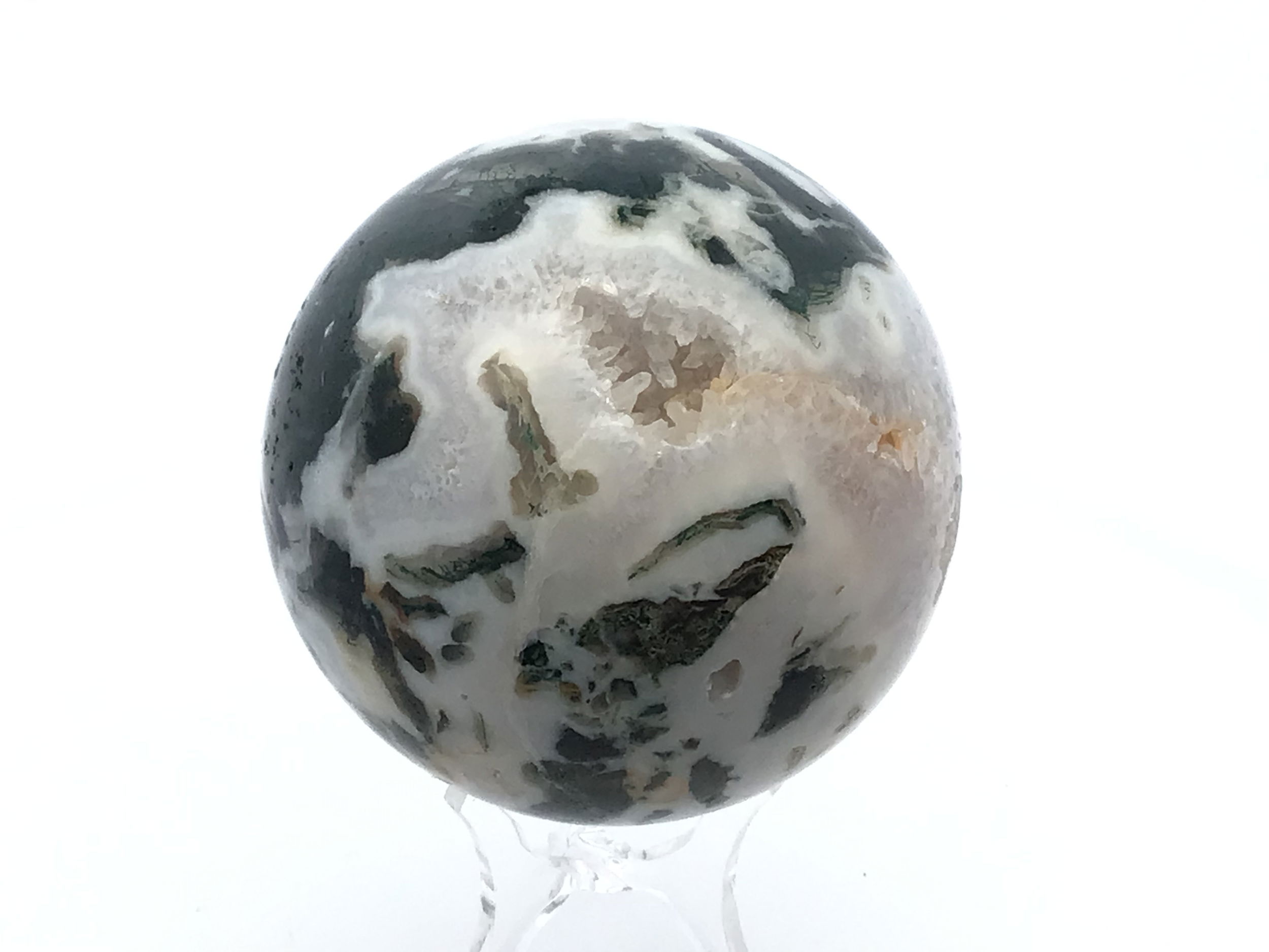 Polished to a smooth, radiant sphere, this genuine Moss Agate captures enchanting forest-green inclusions and earthy patterns, each piece uniquely reflecting nature’s artistry. Resting on a minimalist Lucite stand, it offers a modern display that complements any setting—from meditation spaces to office desks.Cherished for its grounding and nurturing qualities, Moss Agate inspires balance, renewal, and a deeper connection to the natural world. This sphere is an elegant addition to crystal collections or a meaningful gift for those drawn to earth’s tranquil energy. Moss Agate Sphere with Lucite Stand