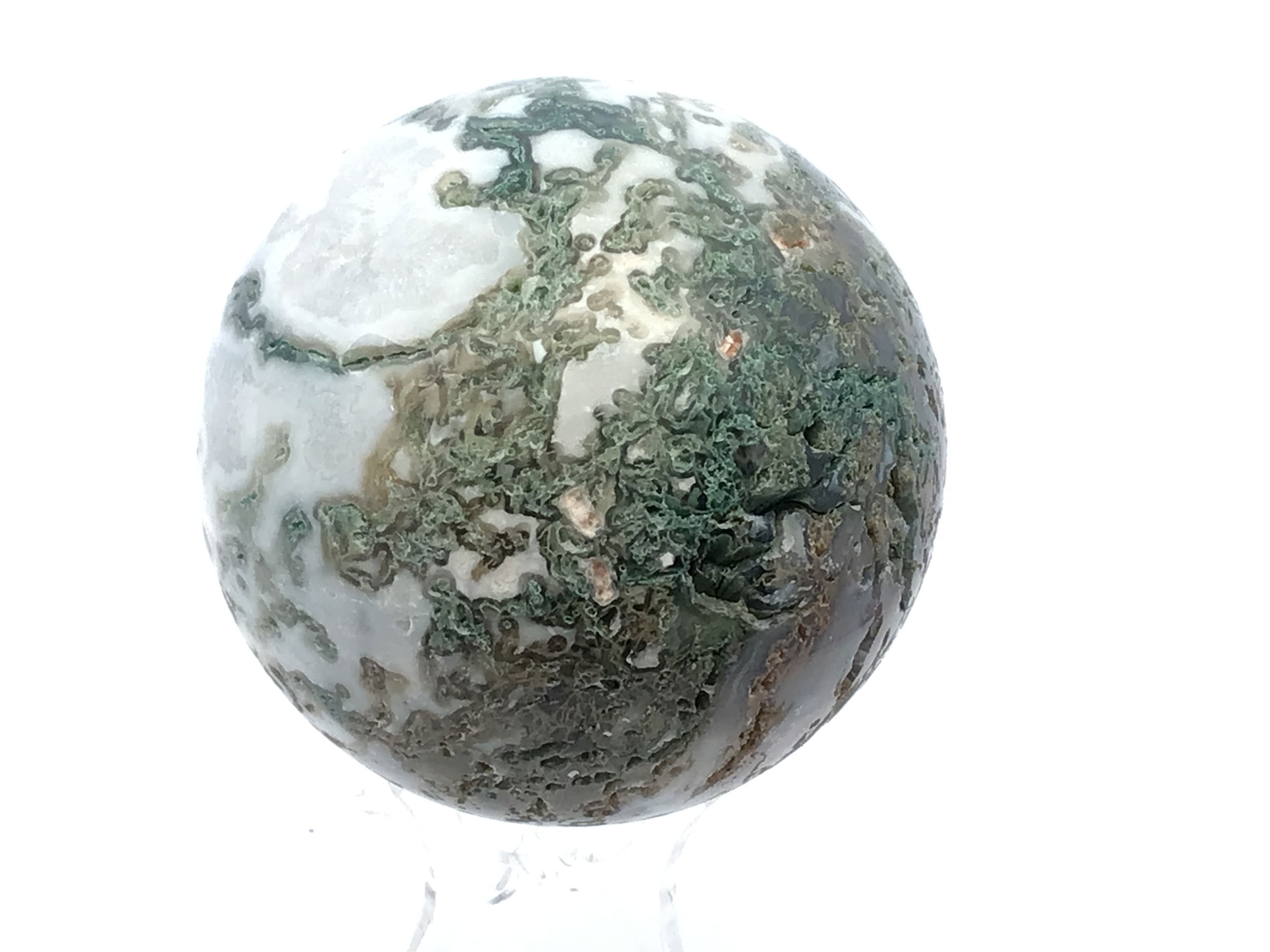 Polished to a smooth, radiant sphere, this genuine Moss Agate captures enchanting forest-green inclusions and earthy patterns, each piece uniquely reflecting nature’s artistry. Resting on a minimalist Lucite stand, it offers a modern display that complements any setting—from meditation spaces to office desks.Cherished for its grounding and nurturing qualities, Moss Agate inspires balance, renewal, and a deeper connection to the natural world. This sphere is an elegant addition to crystal collections or a meaningful gift for those drawn to earth’s tranquil energy. Moss Agate Sphere with Lucite Stand