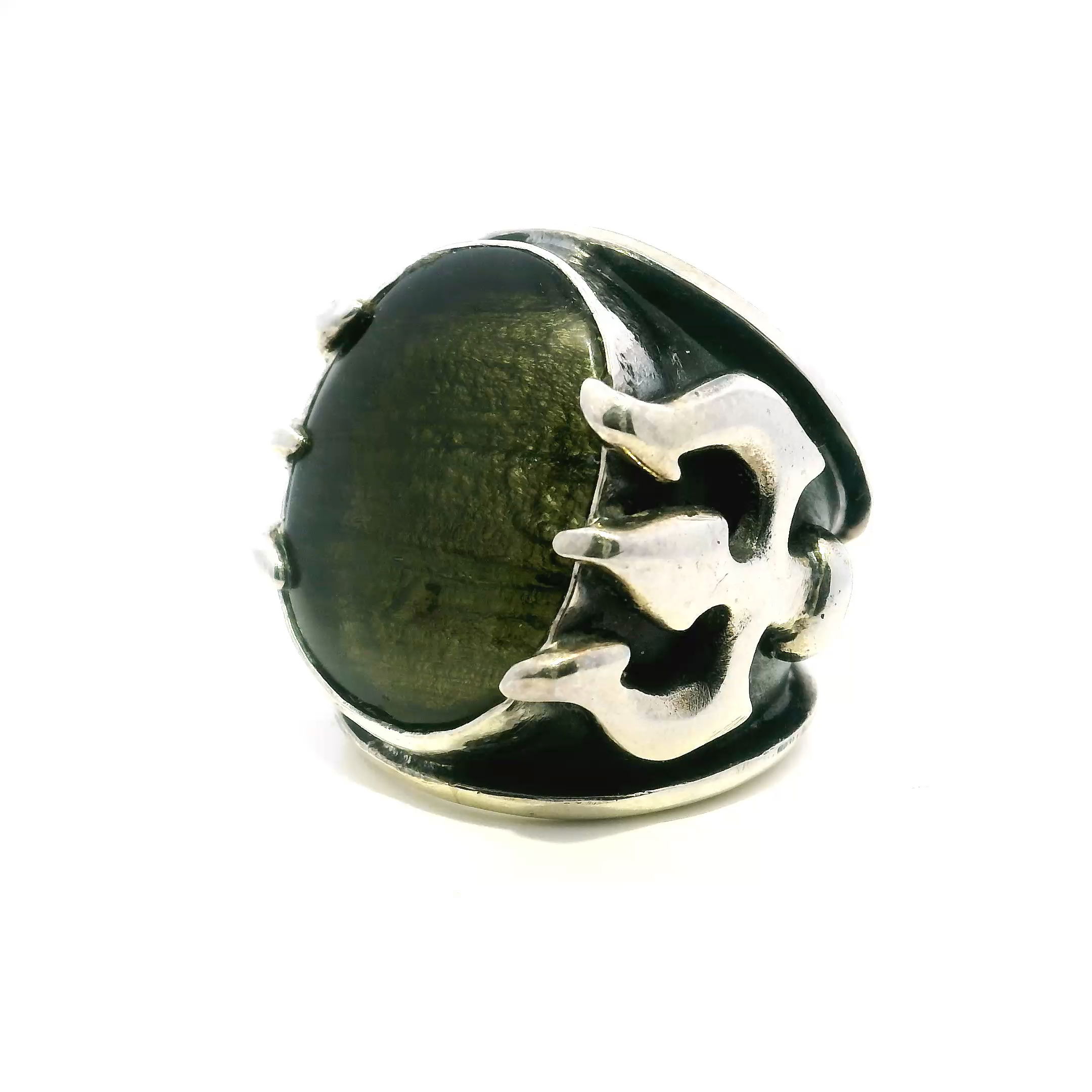 Elevate your style with this striking Moldavite Ring in 925 Sterling Silver, designed for comfortable everyday wear in size 8. The low-profile cabochon of genuine Moldavite glows with a captivating green hue, set atop a distinctive trident-inspired band.Linear striations along the band add a modern artistic touch, perfectly balancing the ring’s earthy mystique with contemporary elegance. Ideal for gemstone lovers and those seeking unique jewelry, this piece is a one-of-a-kind statement that blends mystical energy with refined sophistication. Moldavite Ring - Low Profile Cabochon on Trident Band with Linear Striations Sz8