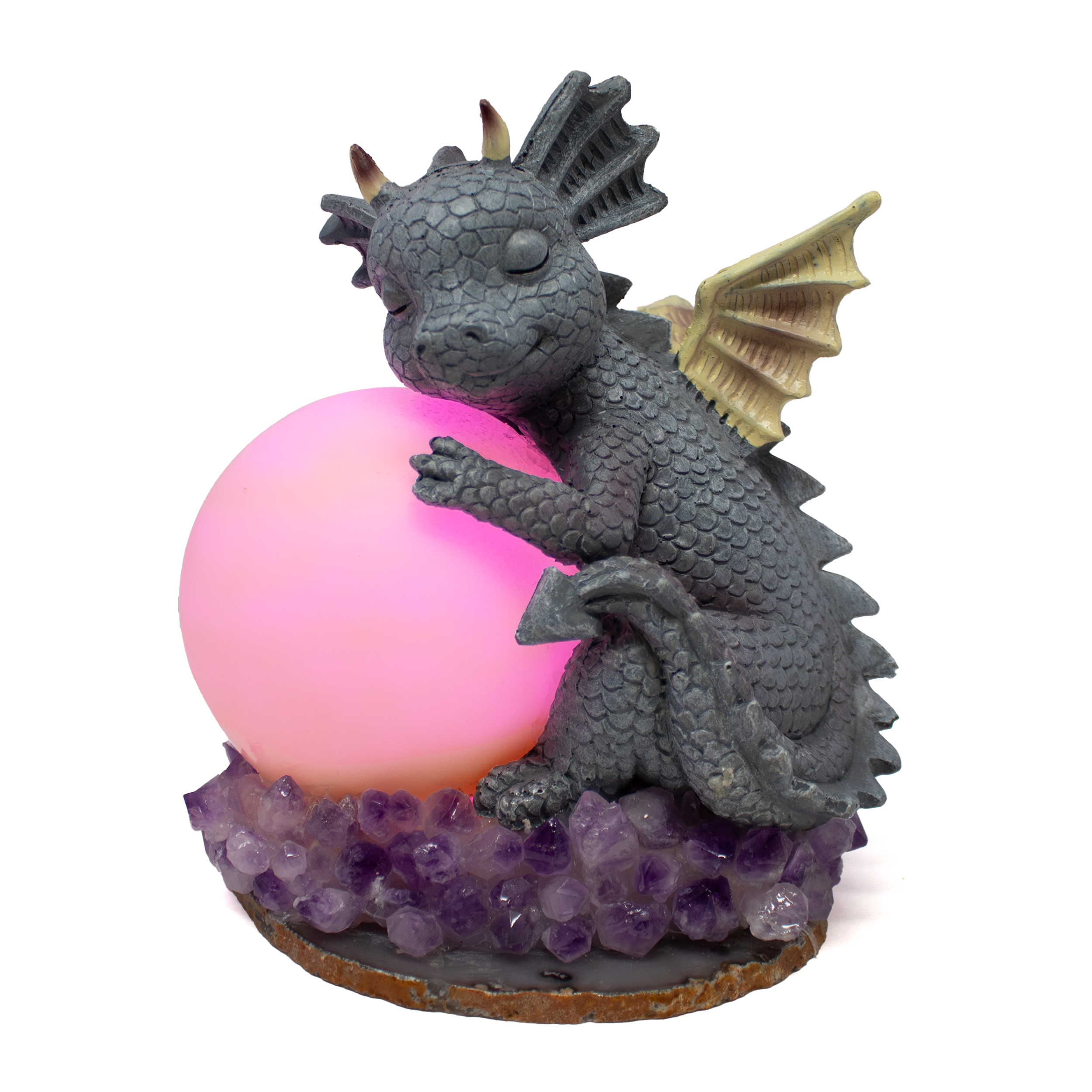 The Clay Polymer Dragon with Moon Table Light casts a soft, celestial glow while bringing fairytale wonder to your space. Handcrafted in exquisite detail, the dragon—formed from polymer clay—gazes protectively at a luminous moon it cradles above a sparkling bed of natural amethyst and agate. Each element is thoughtfully placed to evoke mystery and magic, blending earthy crystal energy with fantasy-inspired design.Perfect for bedside ambiance or whimsical accents in reading nooks and sacred spaces, this lamp turns ordinary evenings into enchanted nights. A captivating gift for fantasy lovers, crystal collectors, or anyone drawn to the mystical, it offers both artistry and gentle illumination in one unforgettable piece. Clay Polymer Dragon w/ Moon on Amethyst & Agate Base Table Light