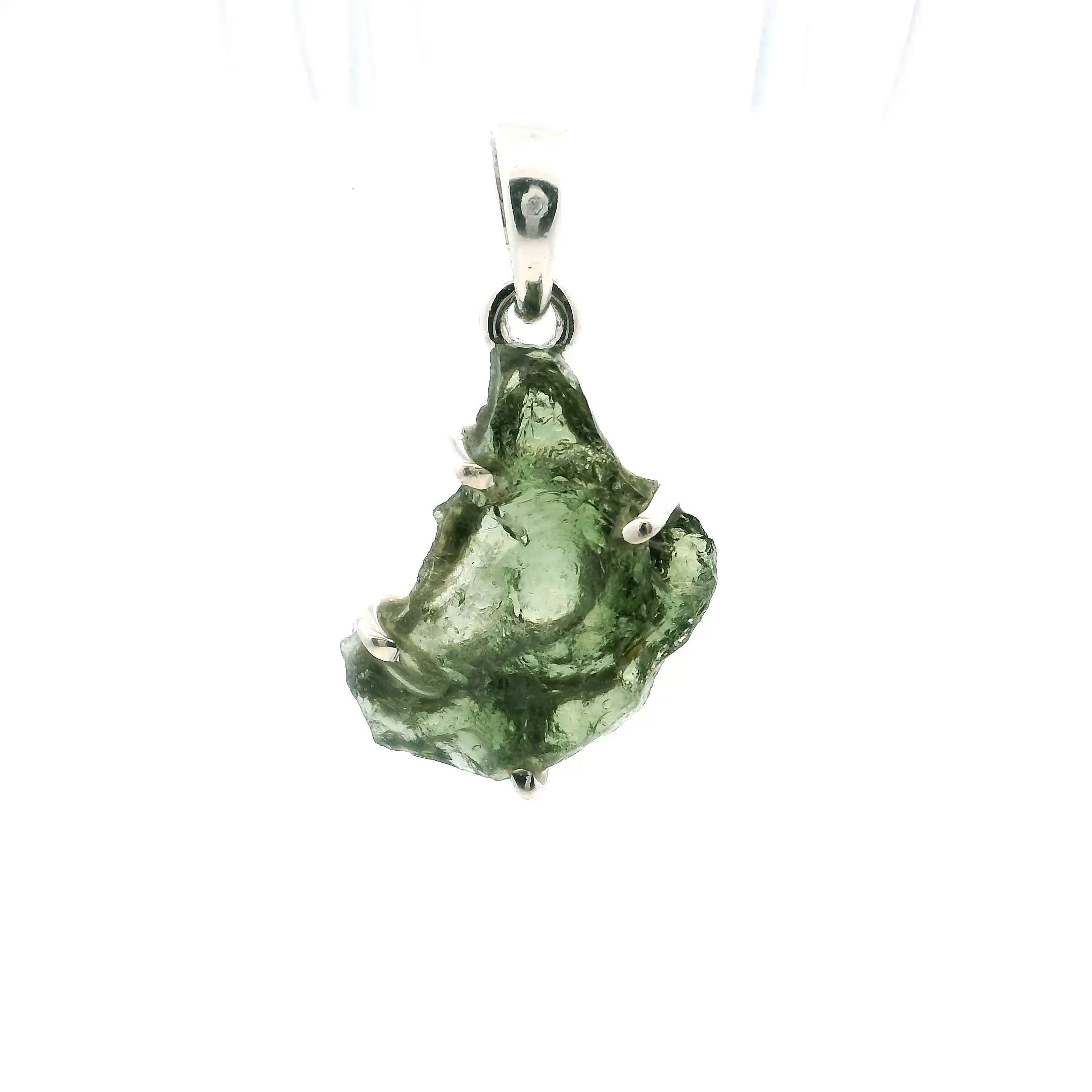 Elevate your style with this exquisite Moldavite Pendant, featuring a unique backwards C freeform design elegantly prong set in genuine 925 sterling silver. Each pendant highlights a raw, natural Moldavite gemstone—celebrated for its deep green hue and celestial origin—ensuring every piece is entirely one of a kind.Meticulously handcrafted, the modern yet organic silhouette brings intrigue and depth to any ensemble. Perfect for collectors, lovers of rare gemstones, or those drawn to meaningful design, this pendant offers a refined statement whether worn alone or layered for a personalized, curated look. Moldavite Pendant - Backwards C Freeform Prong Set in 925 Sterling Silver