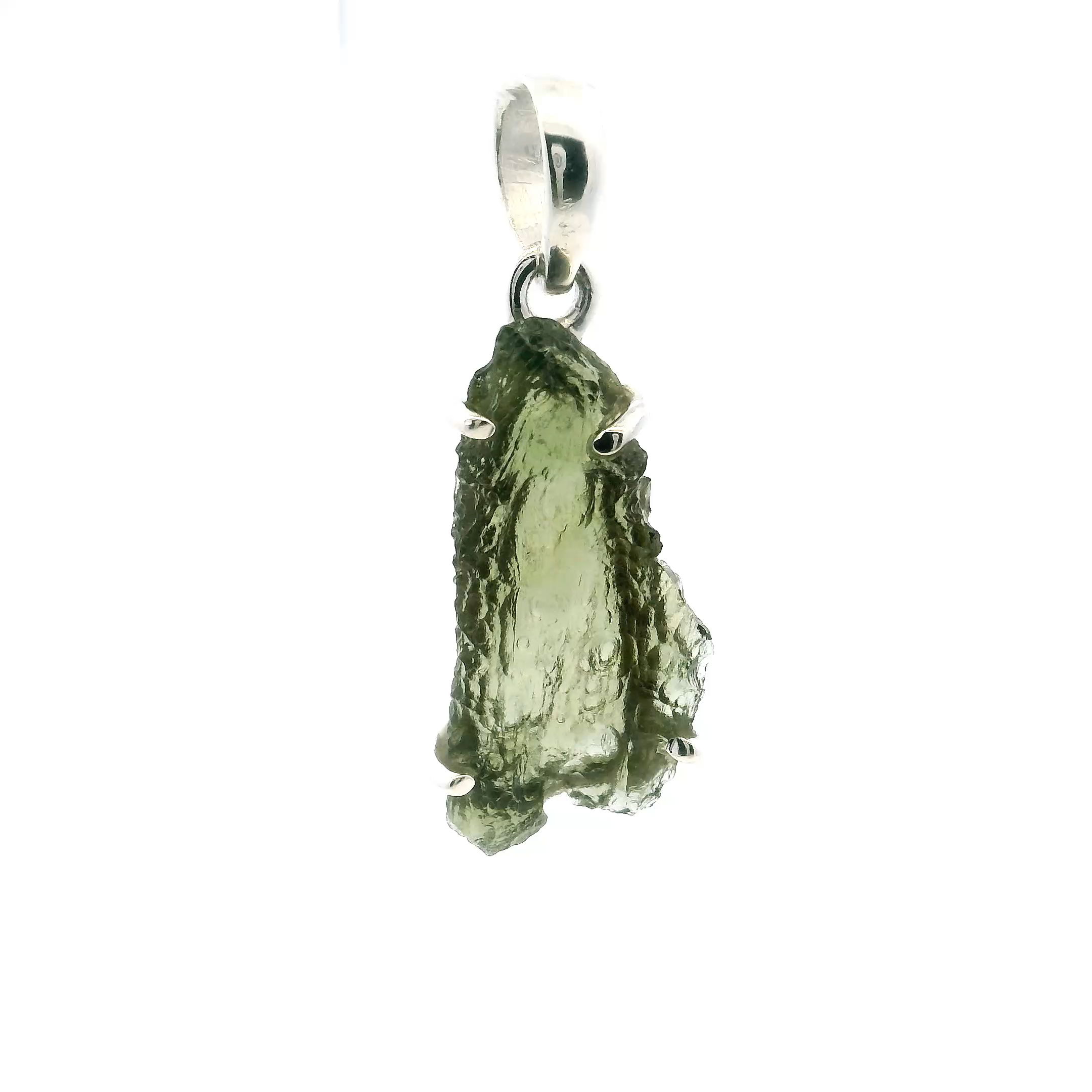 Discover celestial elegance with this one-of-a-kind Moldavite Pendant, featuring a captivating face profile design in a freeform prong setting. Handcrafted in shimmering 925 sterling silver, the raw Moldavite gemstone reveals its ethereal green hues and naturally textured surface, celebrated for both beauty and cosmic origin.The artistic silhouette highlights the stone’s organic shape, creating a pendant that is as meaningful as it is striking. Ideal for those who cherish rare gems and bold design, this piece invites transformative energy and timeless style into any jewelry collection. Moldavite Pendant - Face Profile Freeform Prong Set in 925 Sterling Silver