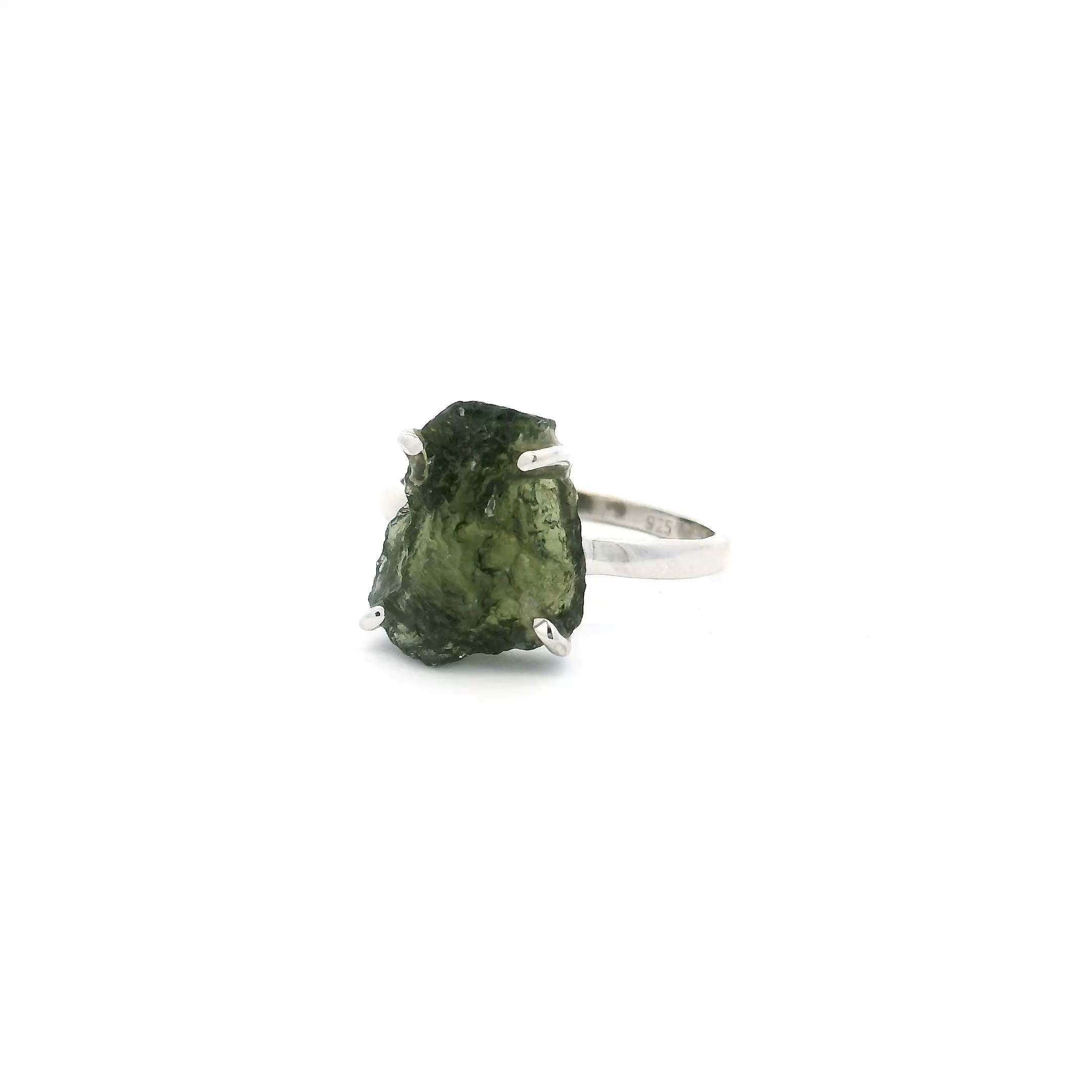 Elevate your jewelry collection with this striking Moldavite Ring, featuring a unique trapezoidal freeform Moldavite gemstone, expertly prong set in luminous 925 sterling silver. Designed in size 7, the rare mossy-green hue of this genuine Moldavite evokes both mystery and elegance, celebrating the stone’s celestial origin and captivating natural form.The handcrafted setting accentuates every organic edge and texture, making each ring a truly one-of-a-kind statement. Ideal for those drawn to meaningful, expressive jewelry, this piece blends raw beauty with refined craftsmanship—perfect for daily wear or as a standout addition to your collection. Moldavite Ring - Trapezoidal Freeform Prong Set in 925 Sterling Silver sz7