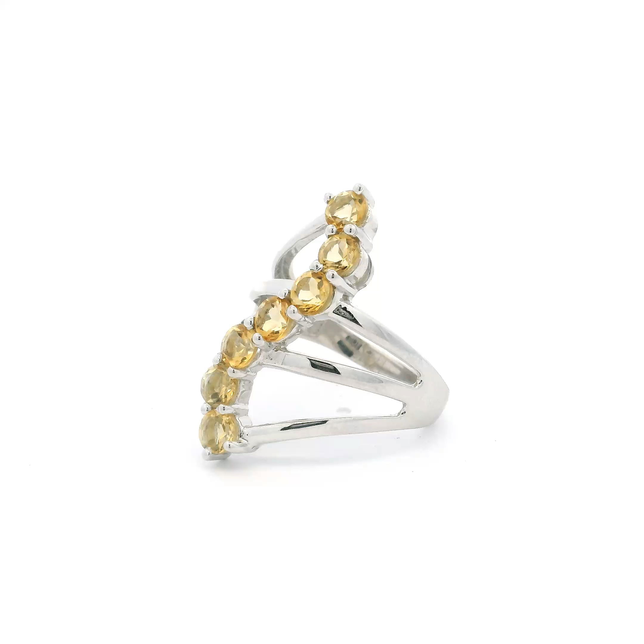 The Citrine Ring features seven faceted round citrine stones arranged in a subtle S-shaped pattern, each prong-set on a triple band of polished 925 sterling silver. Sized at 9 for a comfortable fit, this ring balances clean lines with warm color, offering a refined yet straightforward statement piece. Its design suits everyday wear or special occasions, blending natural beauty with thoughtful craftsmanship. Citrine Ring - 7 Faceted Rounds in S-Shaped Design on Triple Band Prong Set in 925 Sterling Silver sz9