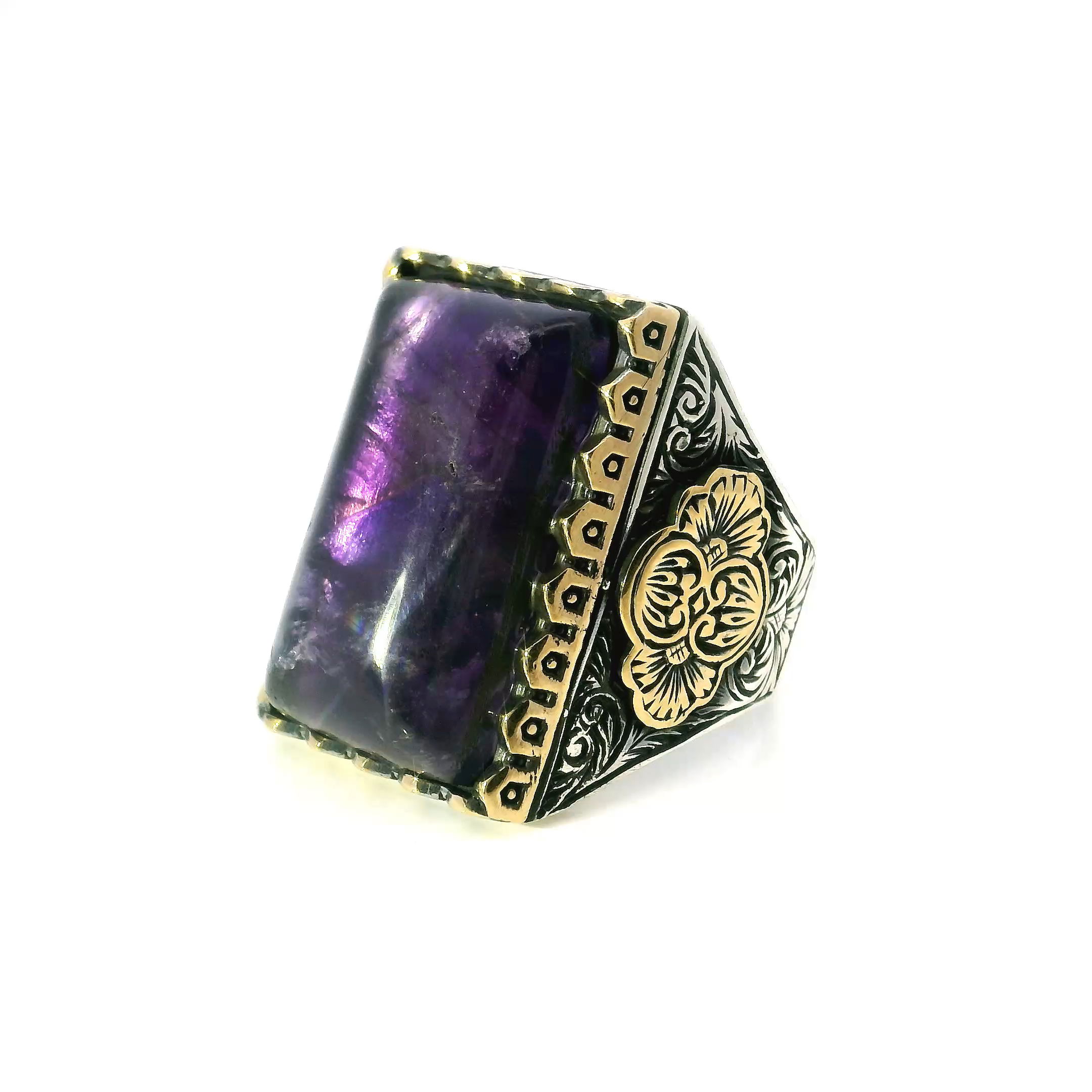 This Amethyst Ring centers on a deep purple rectangular pillow cabochon, set in gold vermeil over 925 sterling silver. The sawtooth bezel frames the stone with bold precision, while subtle swirl and floral details add intricate character. Sized at 12, the ring balances strong design with refined craftsmanship, suitable for everyday wear or special moments. Amethyst Ring - Rectangle Pillow Cabochon in Designer Sawtooth Setting with Swirl & Flower Details in Gold Vermeil with 925 Sterling Silver sz12