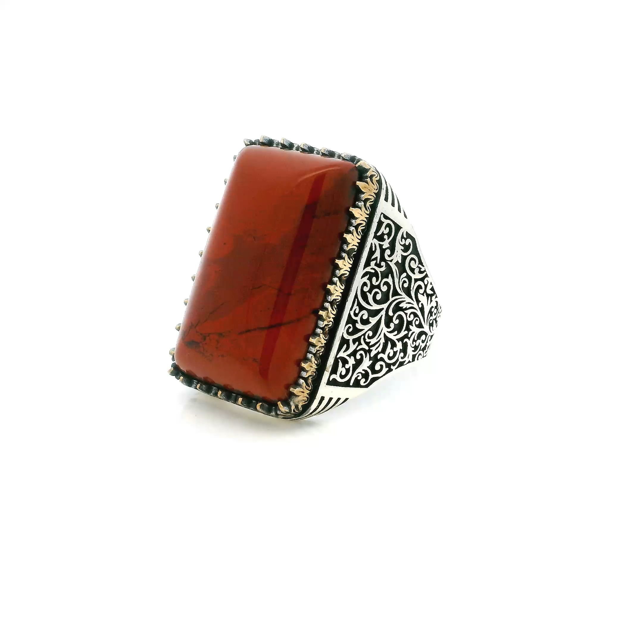 Bold and distinctive, this Red Jasper Ring features a striking rectangle pillow cabochon showcasing rich earthy reds and unique natural patterns. The stone is set in a custom sawtooth bezel of solid 925 sterling silver, accented with gold vermeil and delicate vine details along the shank. Sized at 10.5, this ring combines organic inspiration with expert craftsmanship, creating a refined statement piece for those who appreciate standout style. Red Jasper Ring - Rectangle Pillow Cabochon in Designer Sawtooth Setting with Vine Details in 925 Sterling Silver with Gold Vermeil Accents sz10.5