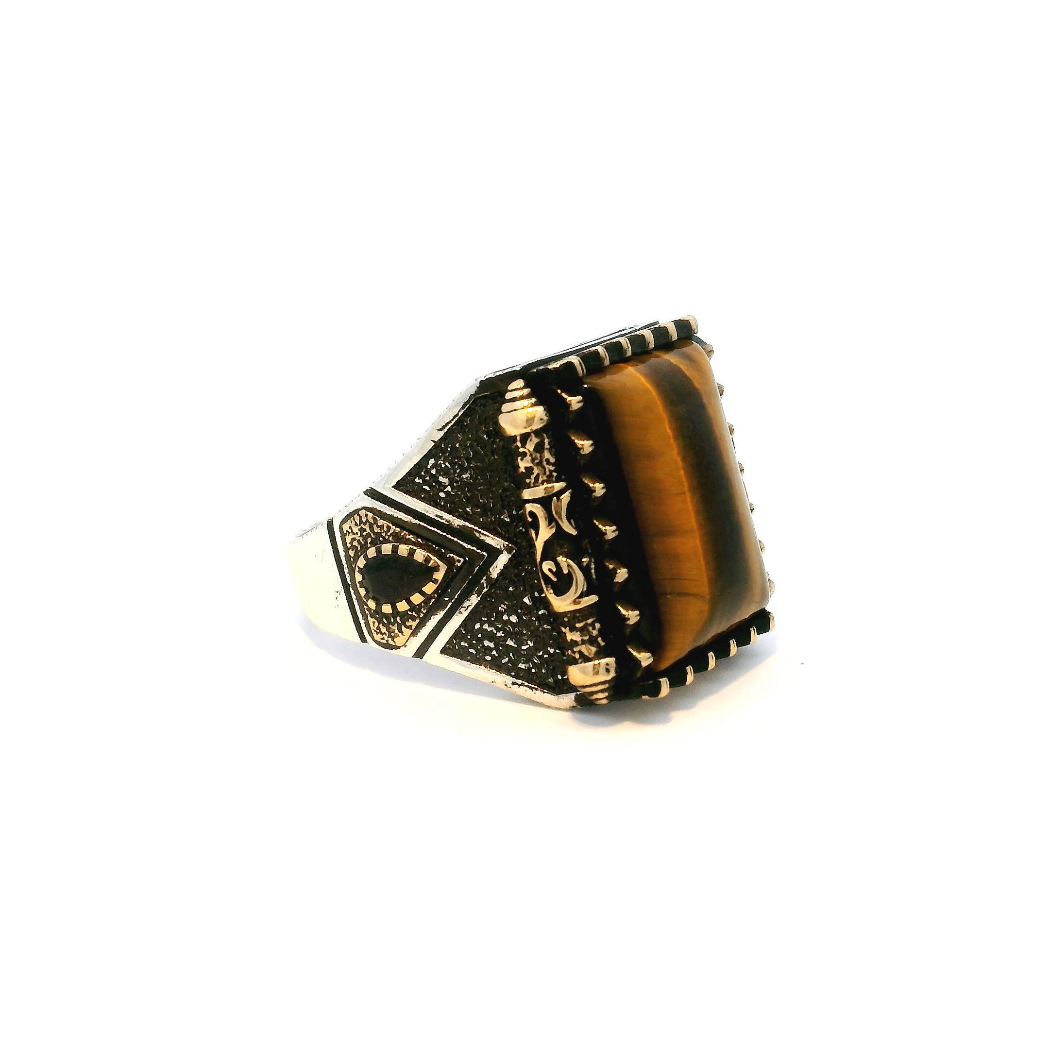 Elevate your style with this bold Tiger’s Eye Ring, designed to capture the essence of strength and sophistication. A striking rectangular pillow cabochon of golden-brown Tiger’s Eye takes center stage, its natural chatoyancy radiating depth and movement. Set in a distinctive sawtooth bezel and framed by faceted black pear-shaped accents, the design is elevated by ornate gold vermeil scrollwork that adds richness and contrast. Crafted in solid 925 sterling silver and sized at 10.5, this ring merges timeless elegance with powerful presence—perfect for the modern man who appreciates fine craftsmanship and symbolic detail in his jewelry. Tigers Eye Ring - Rectangle Pillow Cabochon in Designer Sawtooth Setting with 2 Faceted Black Side Pears & Scroll Details in Gold Vermeil with 925 Sterling Silver sz10.5