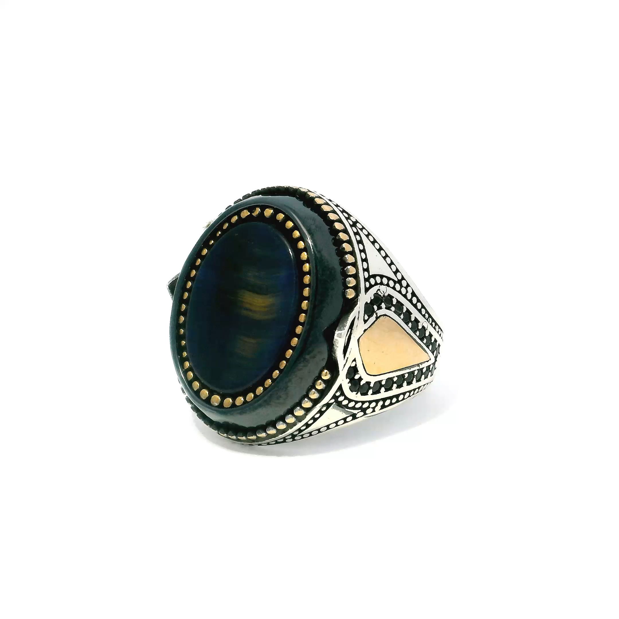 Make a commanding impression with this bold Blue Tigers Eye Ring, meticulously designed in 925 sterling silver and finished in a versatile size 10.5. At the center lies an entrancing oval blue tigers eye, its chatoyant bands shimmering beneath a sleek flat bezel. Rich gold vermeil beading frames the stone, highlighting its natural luster, while a larger black oval element anchors the band in dramatic contrast. A precision-set row of black pavé nanostones adds depth and refined intensity. Designed for those who favor powerful, modern adornment, this ring is a fusion of elegance and edge—crafted to stand out and endure. Blue Tigers Eye Ring - Oval Flat Bezel Set with Gold Vermeil Bead Details & Larger Black Oval & Black Pave Nanostones on Band in 925 Sterling Silver sz10.5