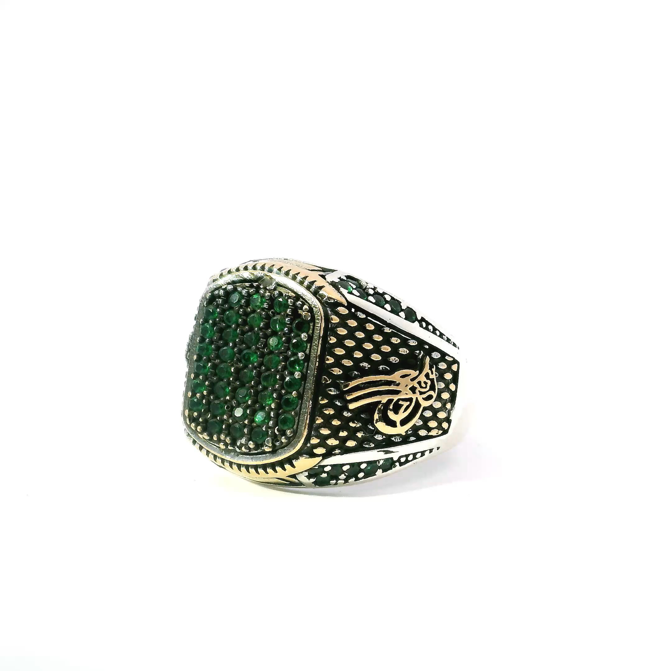 Elevate your style with the Emerald Nanostone Ring, a bold fusion of refined design and vivid color. At its center, a cluster of emerald nanostones forms a luminous rounded rectangle, each stone gleaming with rich green intensity. Additional pavé emeralds adorn the sides, enhancing the piece with intricate sparkle and visual depth. Framed in radiant gold vermeil and grounded by a solid 925 sterling silver band, this size 10.25 ring delivers striking contrast, enduring craftsmanship, and undeniable presence. A standout piece for everyday distinction or special moments, it embodies confident elegance in every detail. Emerald Nanostone Ring - Multiple Emerald Nanostones in Rounded Rectangle Shape with Side Emerald Nanostone Details in Gold Vermeil with 925 Sterling Silver sz10.25