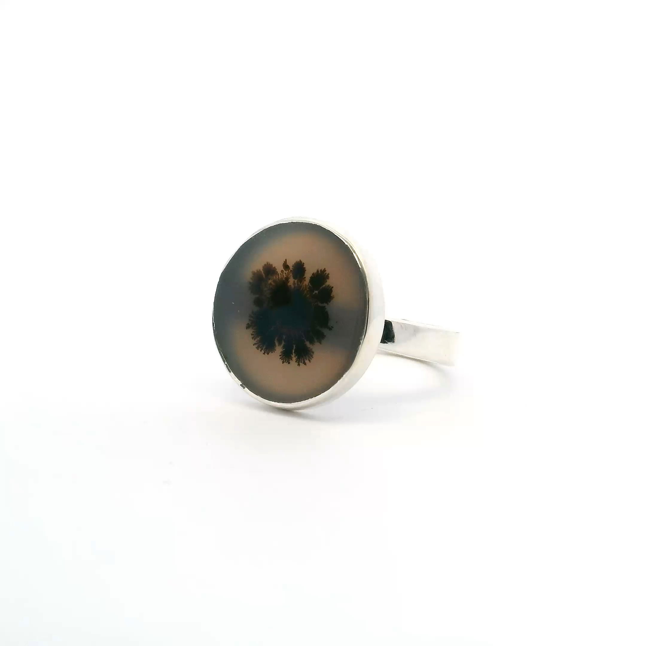 Discover natural artistry with our Dendritic Agate Ring, featuring a unique round cabochon showcasing a striking single centered dendrite cross-section. Expertly bezel set in minimalist 925 sterling silver, this elegant size 7 ring lets the beautiful black fern-like inclusions stand out against the milky agate. Perfect for everyday wear or special occasions, this one-of-a-kind piece offers timeless style and a touch of earthy sophistication to any jewelry collection. Dendritic Agate Ring - Round Cabochon with Single Centered Dendrite Cross-section Bezel Set in Simple 925 Sterling Silver sz7