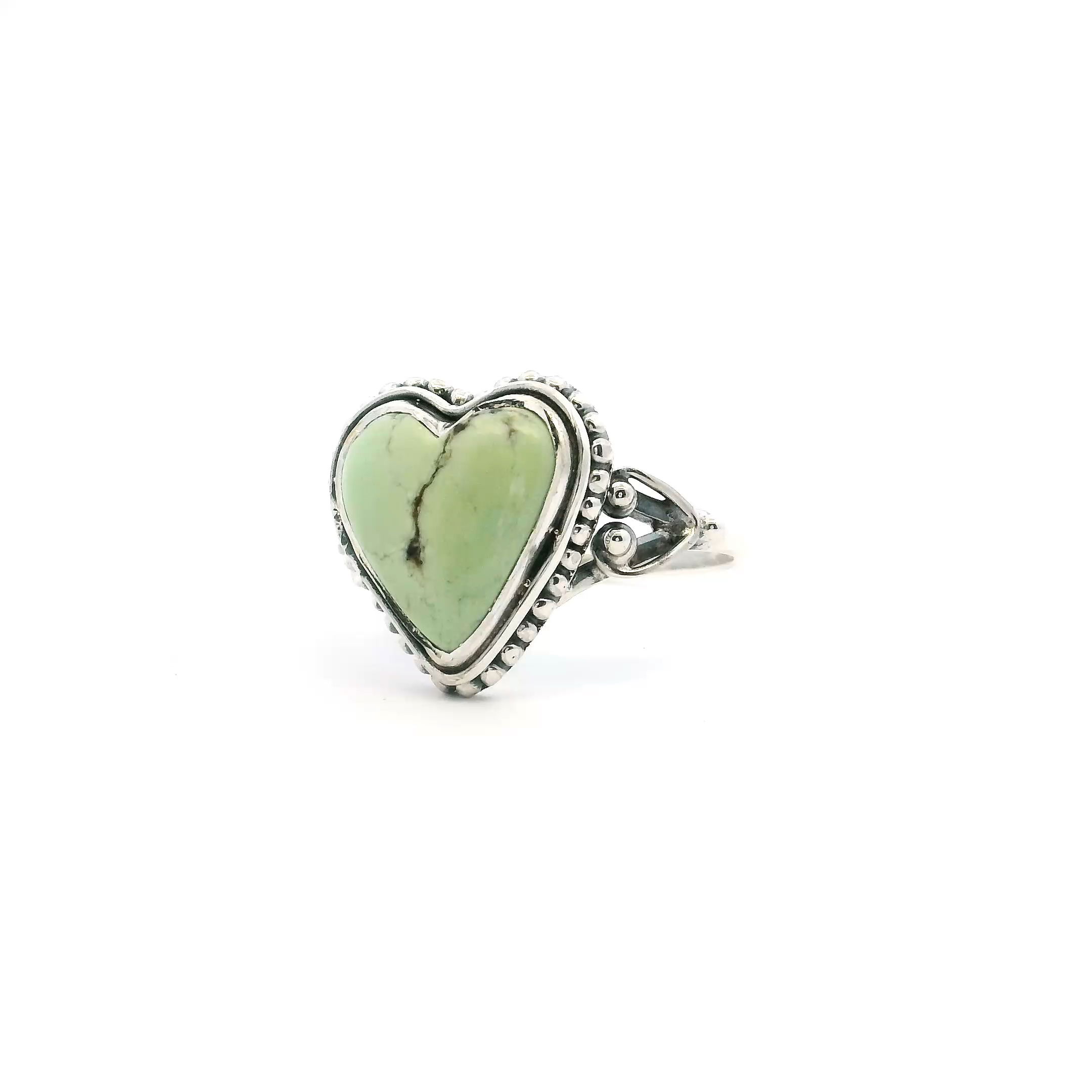 Add a splash of character to your collection with this Lemon Chrysoprase Heart Ring, meticulously handcrafted in solid 925 sterling silver. Featuring a vibrant lemon chrysoprase cabochon, this unique stone showcases a striking dark brown crack running through its heart-shaped center, making it truly one-of-a-kind. The bezel setting is adorned with delicate beaded accents, while the double band adds a modern, alluring touch. Sized for a comfortable fit (size 9), this artisanal ring effortlessly balances bold color and natural beauty, making it the perfect statement piece for any women’s jewelry collection. Lemon Chrysoprase Ring - Heart Cabochon with Dark Brown Crack in Middle Bezel Set with Beaded Accents on Double Band in 925 Sterling Silver sz9