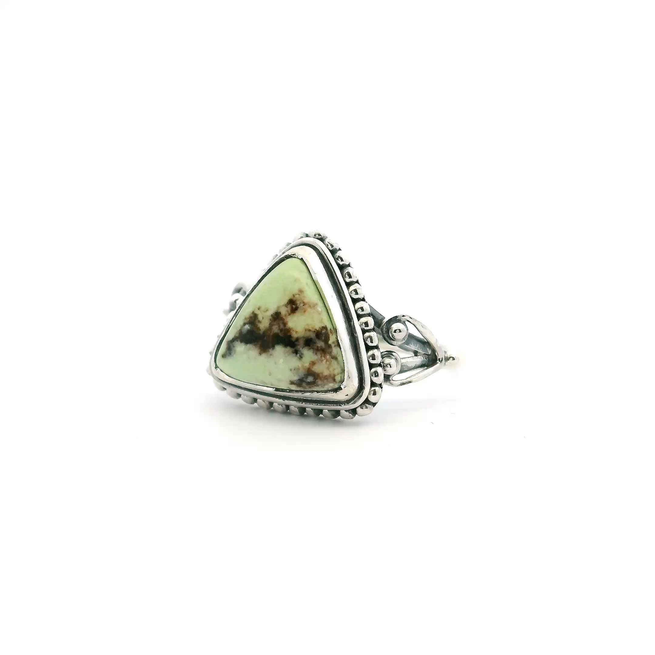 Elevate your jewelry collection with this striking Lemon Chrysoprase Ring, expertly crafted in 925 sterling silver. Featuring a distinctive triangle cabochon of vivid lemon chrysoprase, this eye-catching gemstone is accented with dramatic dark brown triangular inclusions, lending a truly one-of-a-kind look. Securely bezel set, the cabochon is adorned with intricate beaded detailing that adds texture and vintage-inspired elegance. The double band design provides a comfortable yet bold profile, perfect for everyday wear or special occasions. At size 7, this unique ring is a perfect statement piece for those who appreciate artistry and natural beauty in women's jewelry. Lemon Chrysoprase Ring - Triangle Cabochon with Dark Brown Triangular Inclusions Bezel Set with Beaded Detail on Double Band in 925 Sterling Silver sz7