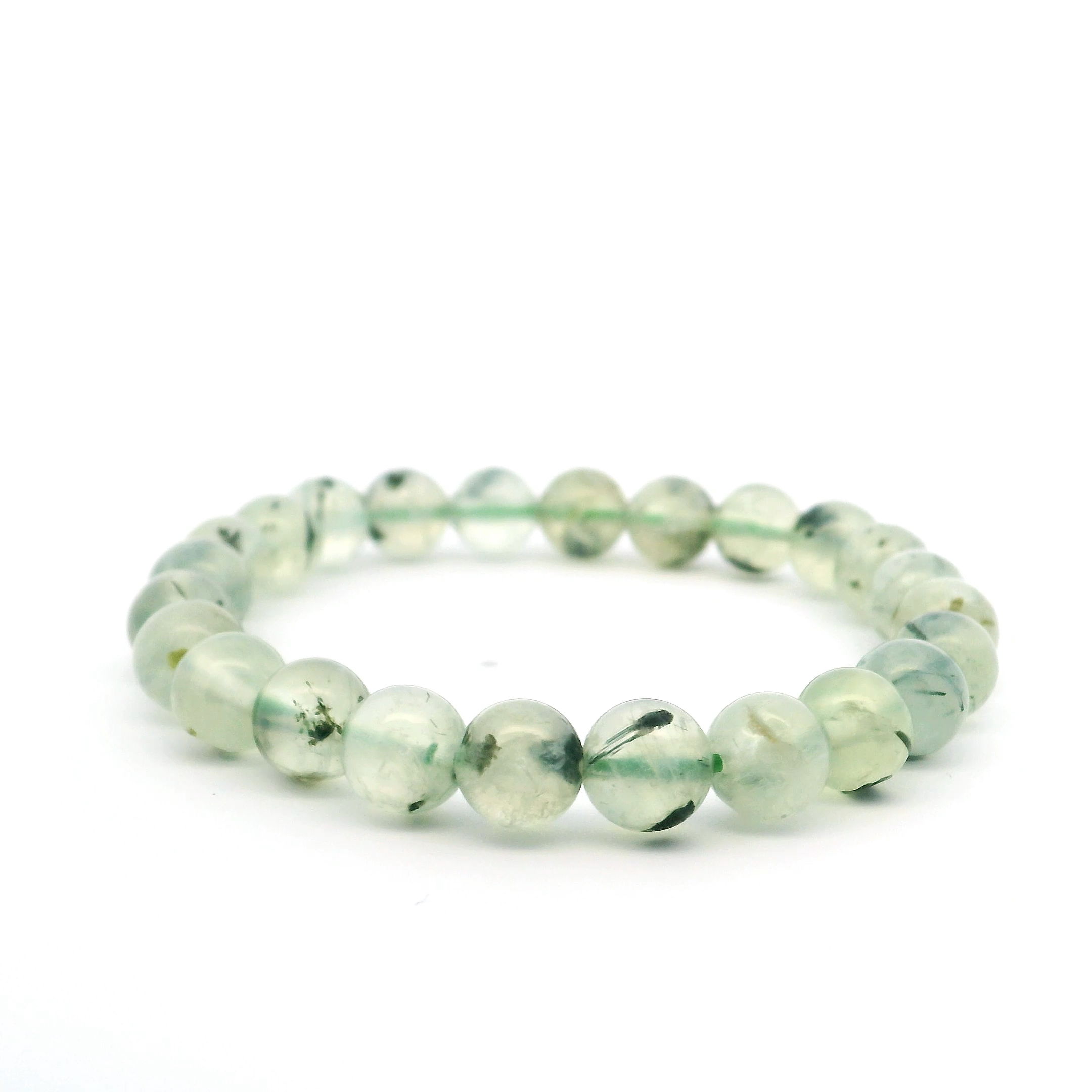 Elevate your everyday style with the Prehnite Beaded Bracelet, featuring smooth 7mm round beads in serene shades of translucent green. Revered as a stone of healing and unconditional love, each prehnite bead offers a gentle glow that soothes the senses and calms the mind. Hand-strung for both comfort and elegance, this bracelet is perfect for stacking with other favorites or making a subtle statement on its own. Ideal for daily wear or as a thoughtful gift, it’s a beautiful way to bring peaceful energy and natural beauty into any jewelry collection. Prehnite Beaded Bracelet - 7mm Round