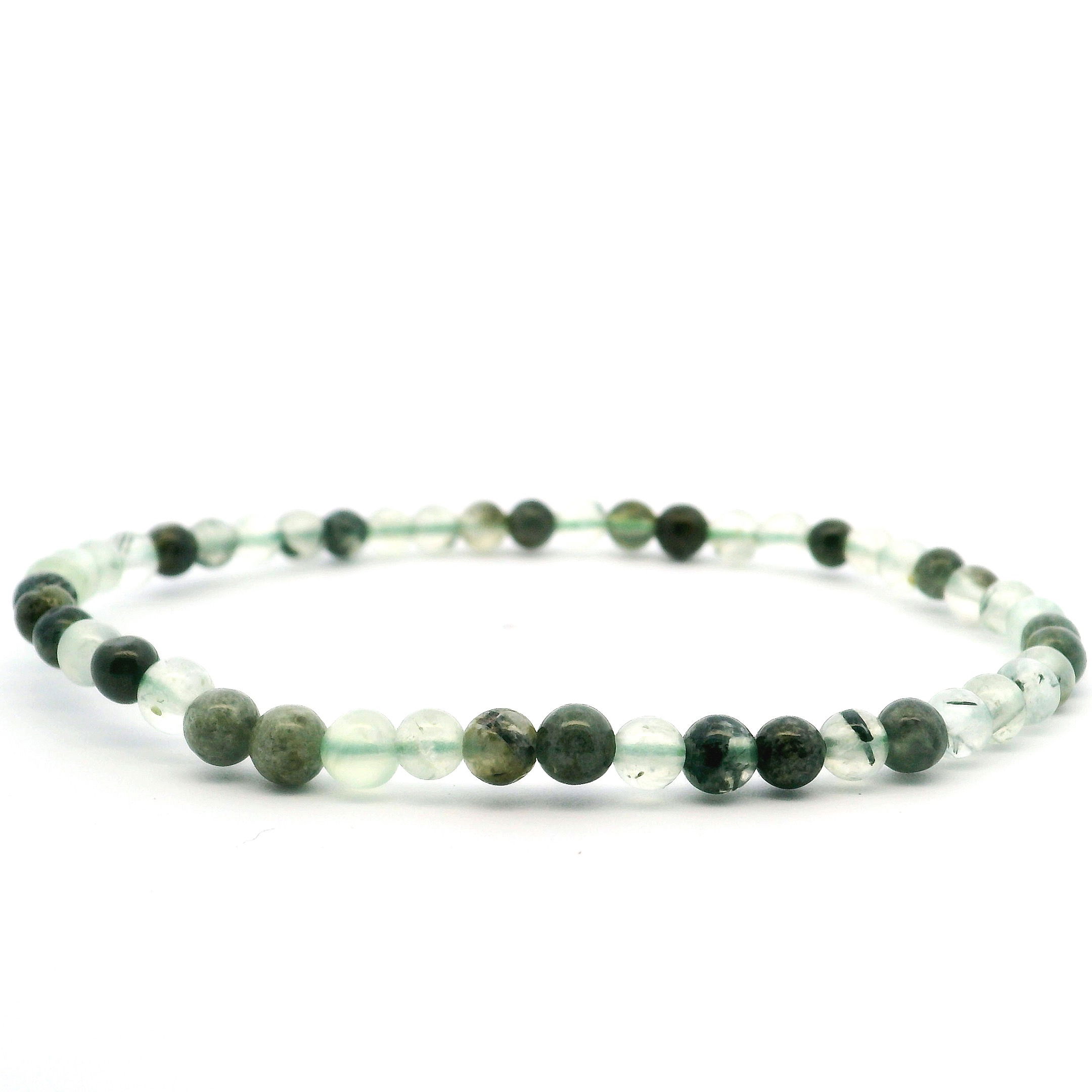 Elevate your everyday style with our Prehnite Beaded Bracelet, crafted from refined 4mm round beads that glow with soft, translucent green tones. Each stone is hand-selected and strung to showcase prehnite’s natural serenity and subtle depth, celebrated for its harmonizing and healing qualities. Lightweight and versatile, it layers effortlessly or makes a quiet statement on its own—an ideal companion for moments of calm, style, and balance. Prehnite Beaded Bracelet - 4mm Rounds