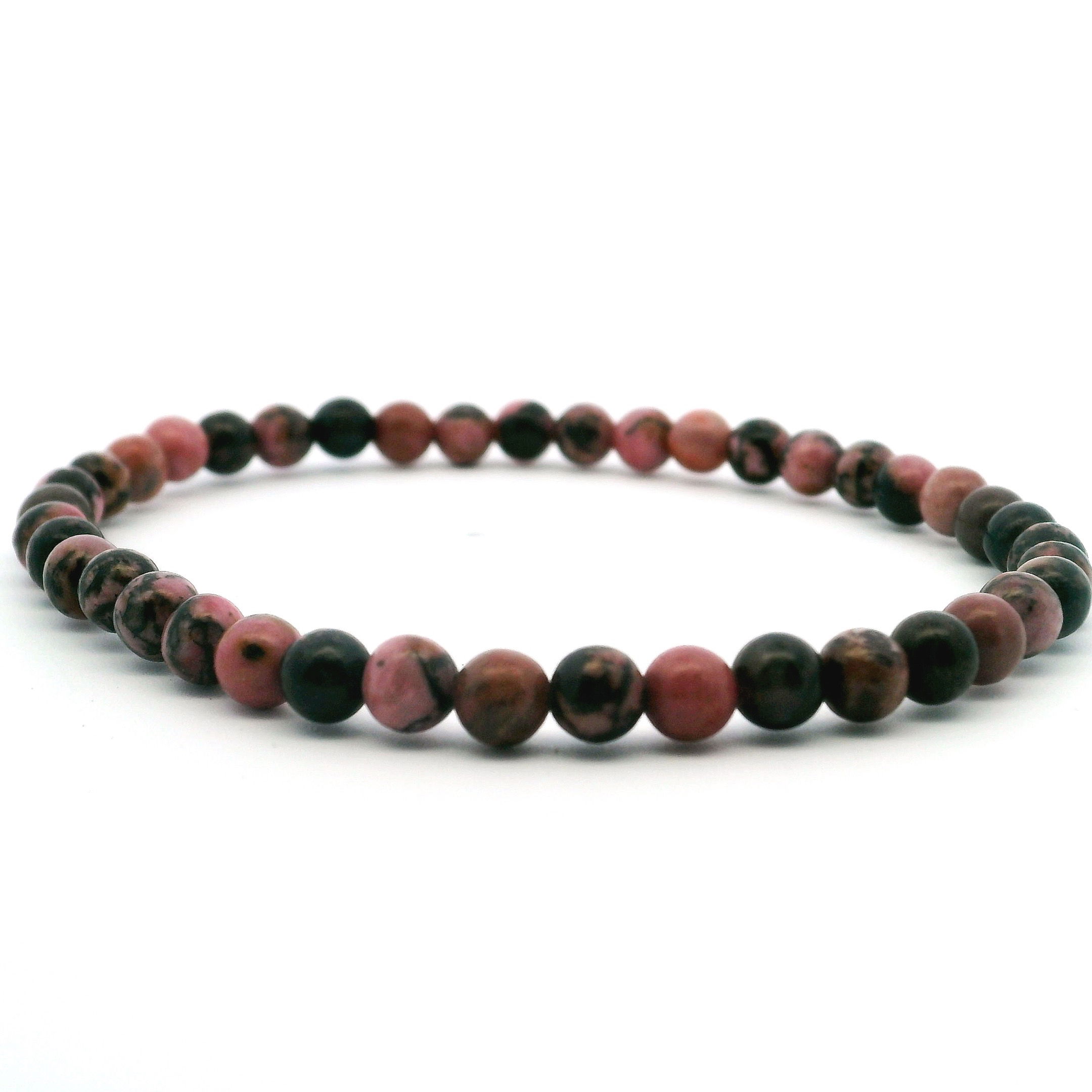 Elevate your everyday style with our Rhodonite Beaded Bracelet, featuring soft 4mm round beads in a harmonious blend of pink tones and natural earthy marbling. Revered as a stone of compassion and emotional balance, rhodonite adds both beauty and meaning to your jewelry collection. Hand-strung on a durable stretch cord for a comfortable fit, this bracelet is perfect for stacking or wearing solo—offering a subtle pop of color and serene energy for any occasion. Rhodonite Beaded Bracelet - 4mm Rounds