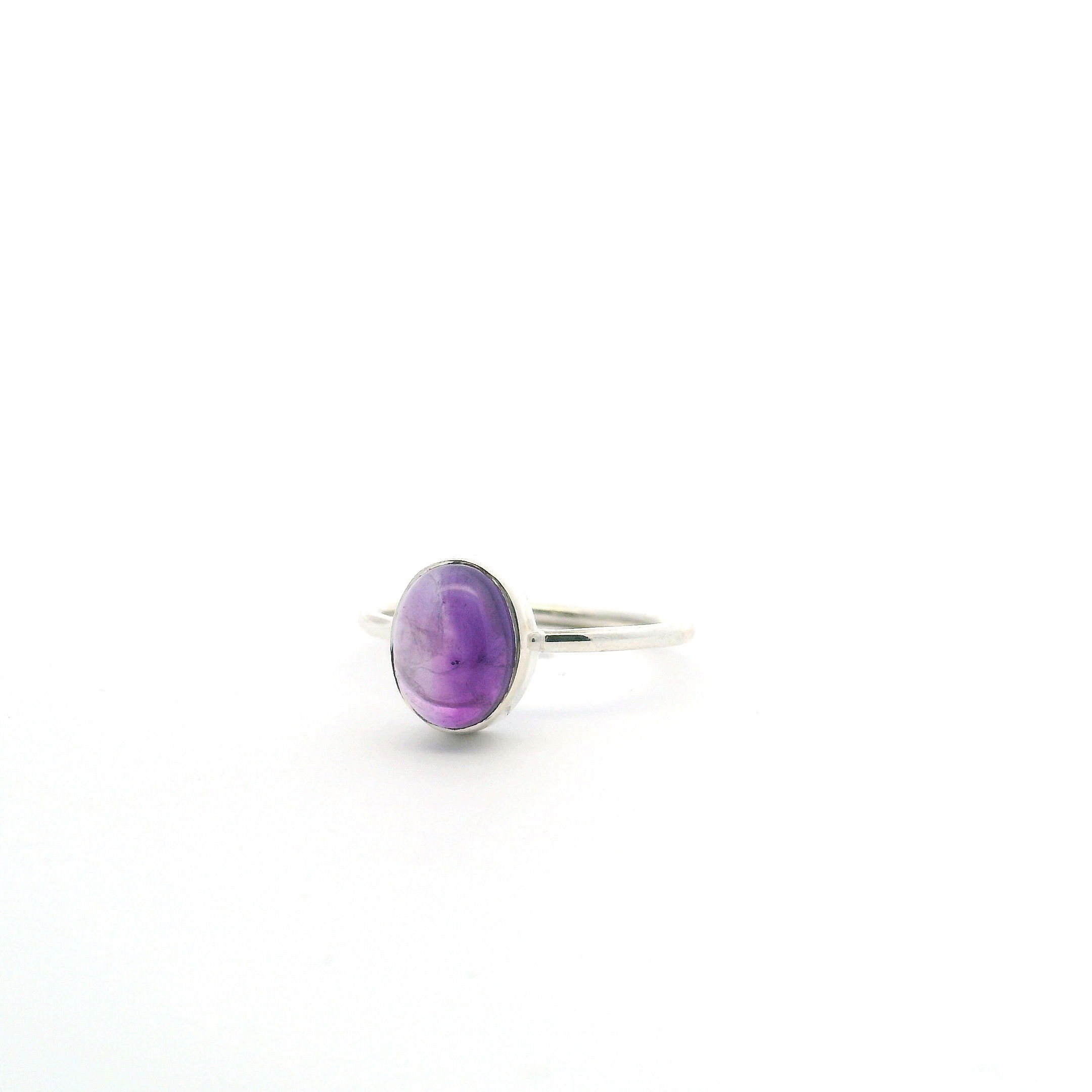 Elevate your style with this elegant Amethyst Ring, featuring a luminous oval cabochon amethyst securely bezel-set in simple 925 sterling silver. Designed for timeless appeal, this size 7 ring showcases the natural beauty of the gemstone, making it a perfect piece for any occasion. Ideal for women's jewelry collections, this amethyst ring blends classic sophistication with minimalist charm—an essential addition to your ring stack or stand-alone statement. Amethyst Ring - Oval Cabochon Bezel Set in Simple 925 Sterling Silver sz7