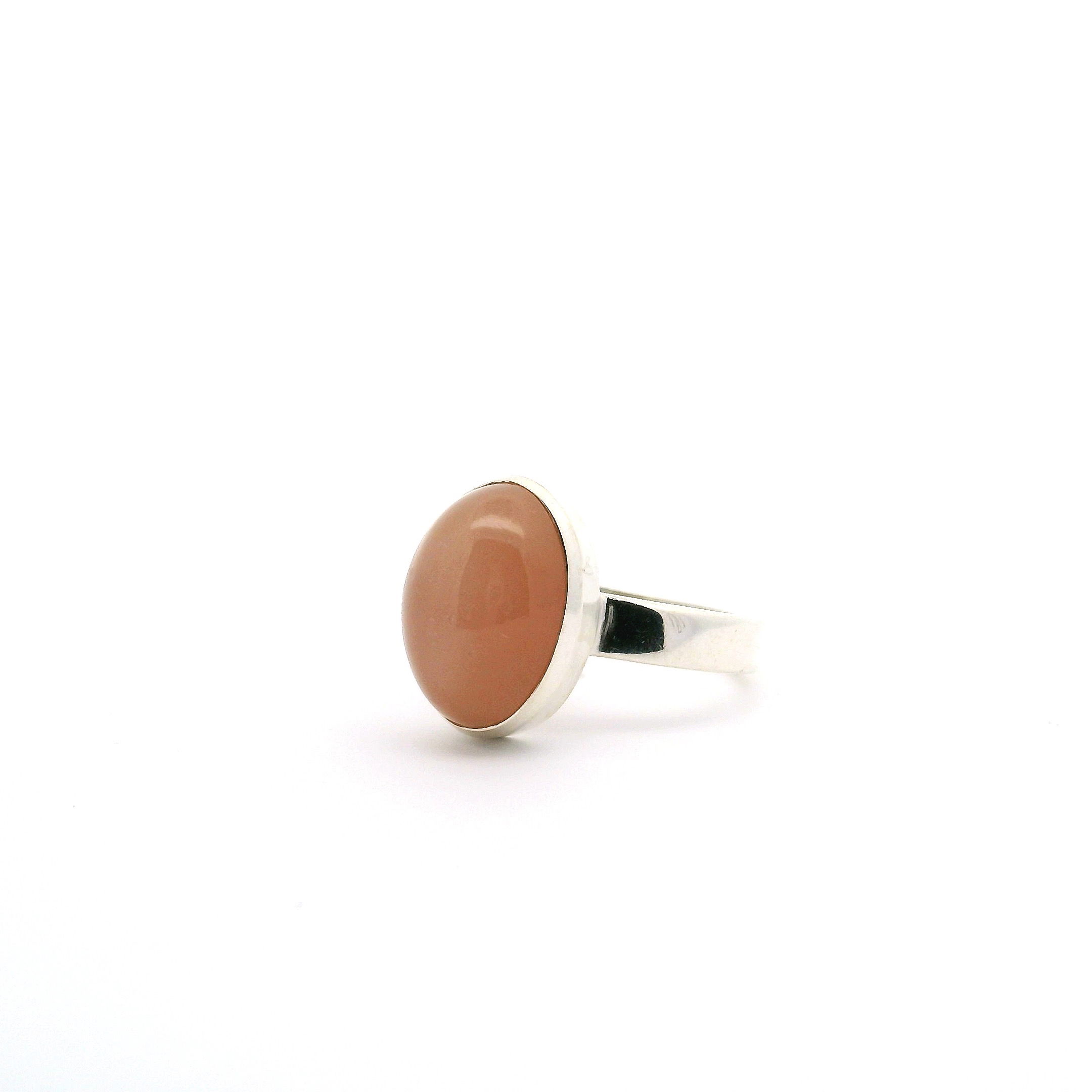 Elevate your jewelry collection with this enchanting Peach Moonstone Ring. Featuring a luminous, oval cabochon peach moonstone, expertly bezel set in simple yet sophisticated 925 sterling silver, this size 8 ring radiates understated elegance. Its classic design highlights the soft, natural glow of moonstone, making it perfect for everyday wear or special occasions. Peach Moonstone Ring - Classic Oval Cabochon Bezel Set in Simple 925 Sterling Silver sz8