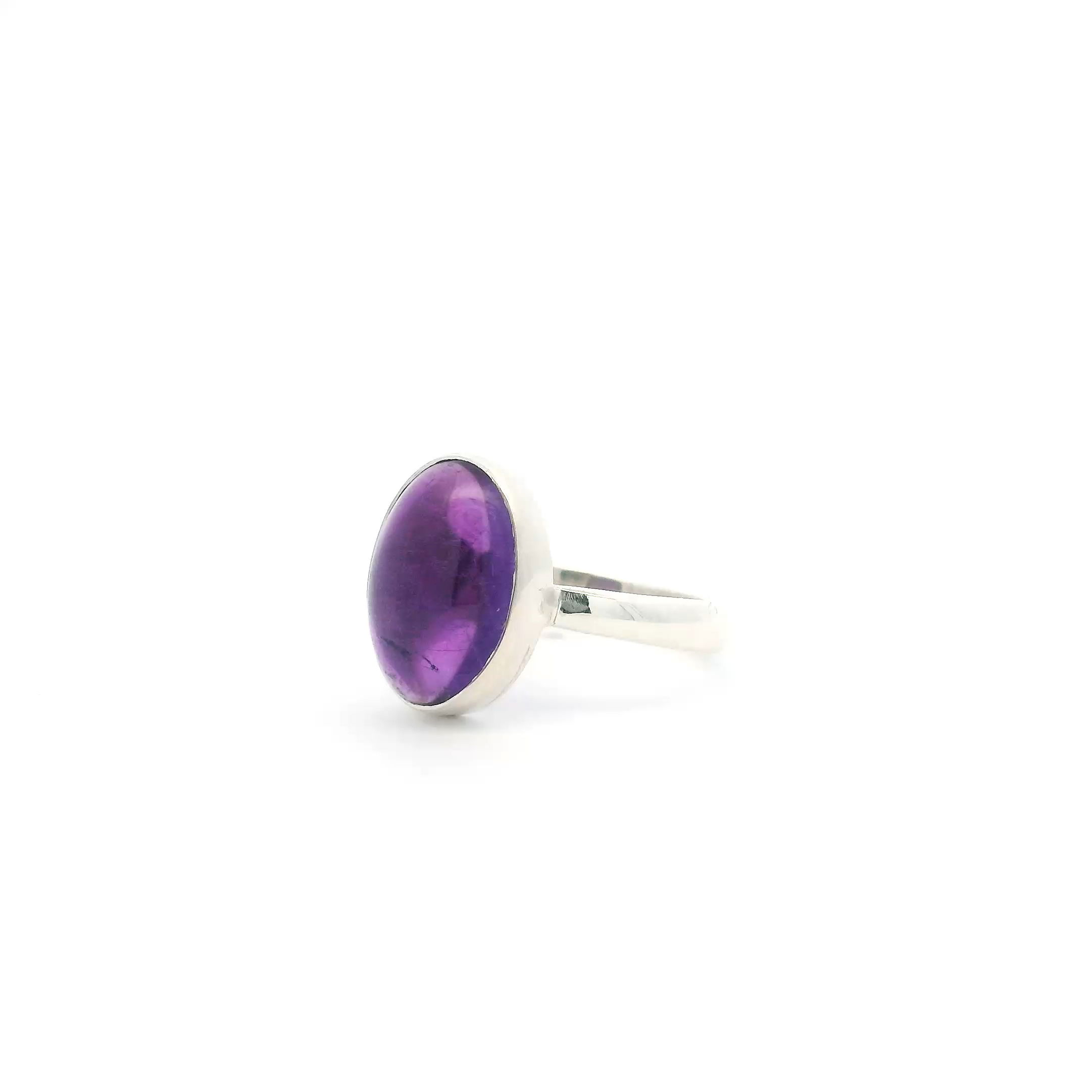Elevate your style with this stunning Amethyst Ring, featuring a luminous oval cabochon amethyst expertly bezel-set in gleaming 925 sterling silver. Its minimalist design lets the rich purple hues of the stone shine, offering a look that is both elegant and versatile. Sized at 7, this handcrafted ring is perfect for stacking or making a subtle statement on its own. Amethyst Ring - Oval Cabochon Bezel Set in Simple 925 Sterling Silver sz7
