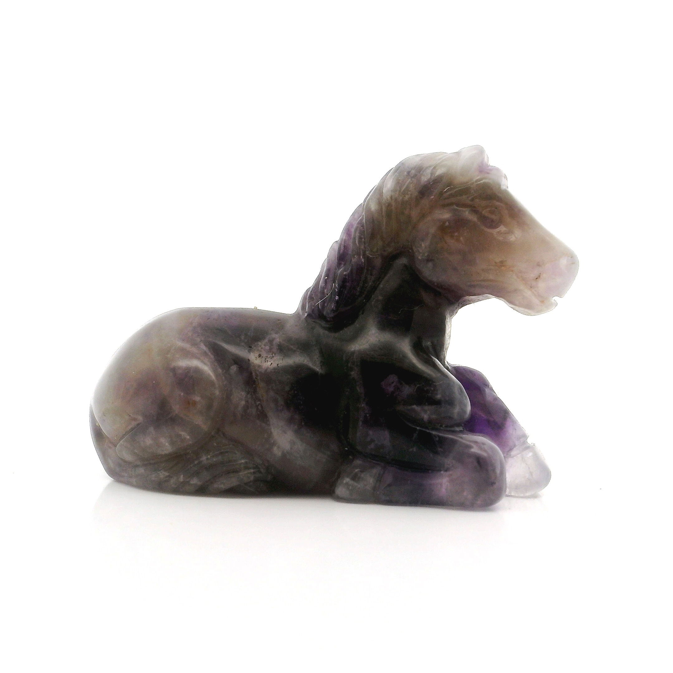 Elevate your space with the serene beauty of our Chevron Amethyst Horse Carving in a graceful laying down posture. Hand-carved from high-quality chevron amethyst, this sculpture showcases stunning bands of deep purple and white, symbolizing peace, strength, and clarity. Its lifelike detail and polished finish make it a captivating centerpiece for your home, office, or meditation area. Ideal as a unique gift for horse lovers, crystal collectors, or anyone seeking a harmonious touch of nature’s artistry, this exceptional piece blends natural elegance with spiritual significance. Each carving is one-of-a-kind, making your gift as unique as the bond it represents. Chevron Amethyst Horse Carving - Laying Down Posture