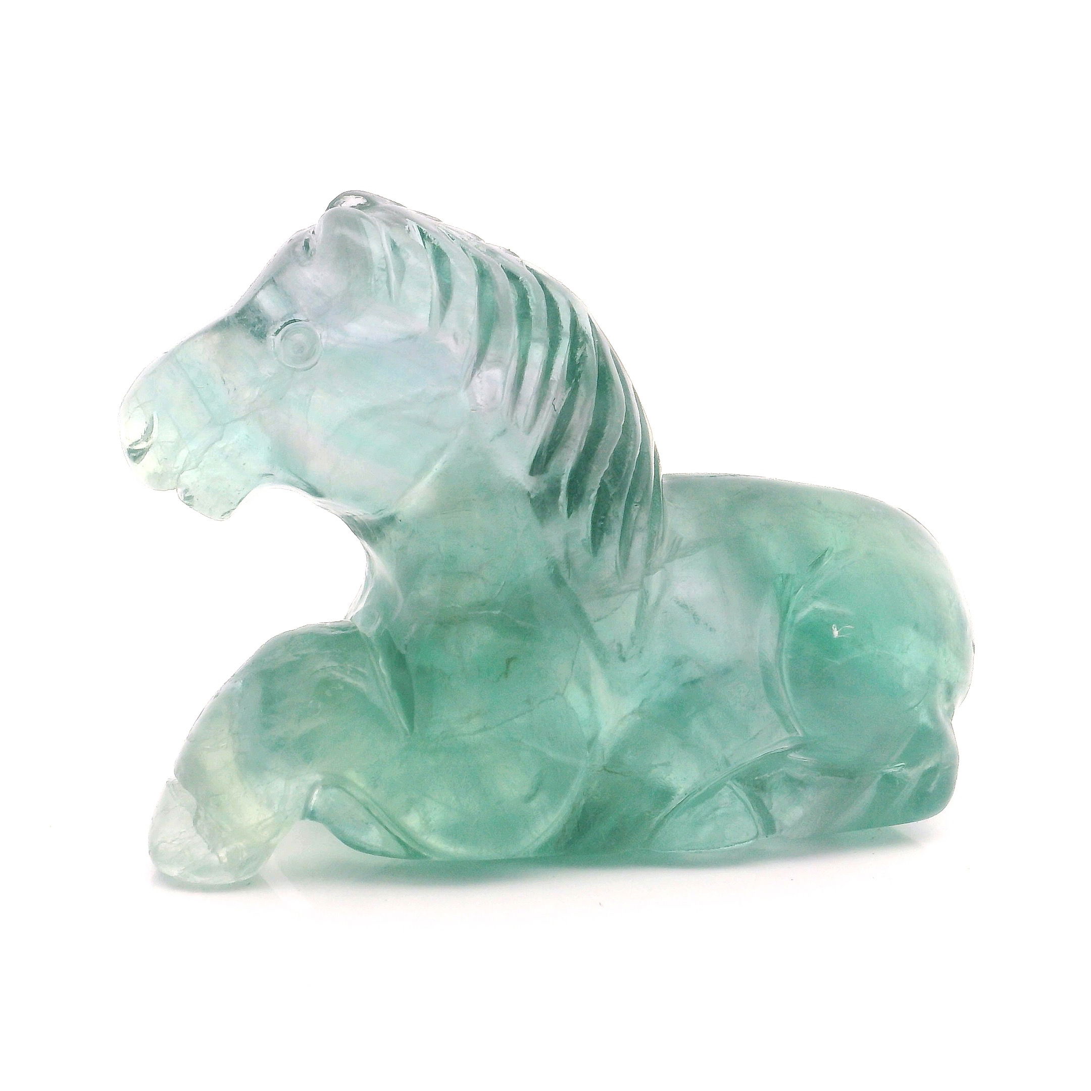 Celebrate the grace and serenity of the equine spirit with this exquisite Green Fluorite Horse Carving in a laying down posture. Hand-carved from genuine fluorite, this sculpture beautifully showcases the stone’s vibrant green hues and natural translucence, making each piece a unique work of art. The horse, depicted in a restful pose, symbolizes tranquility, protection, and gentle strength—an ideal addition for collectors, animal lovers, or anyone seeking a touch of calming energy in their space. Green Fluorite Horse Carving - Laying Down Posture