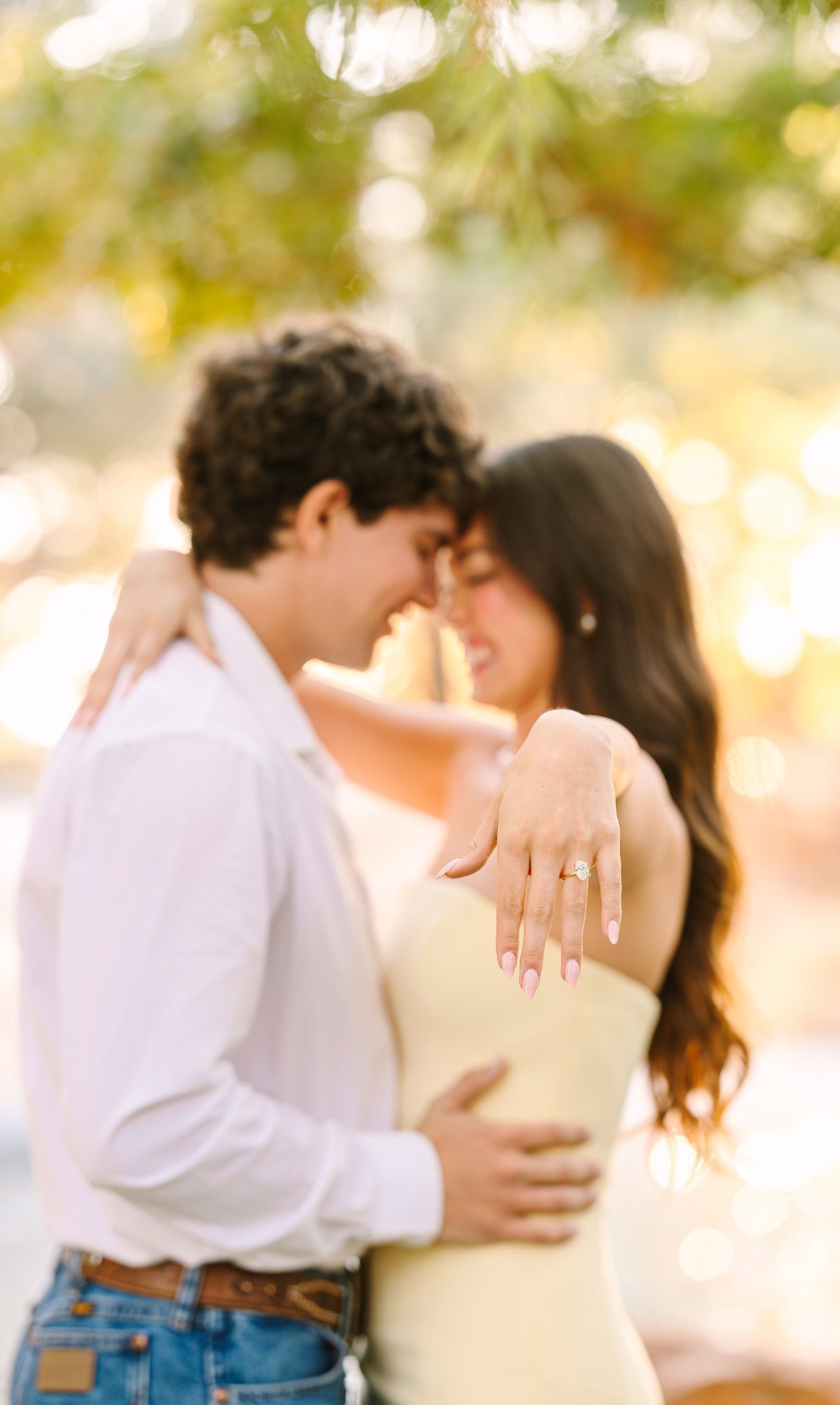 Madi Grace showing her engagement ring with Cory in a sunlit engagement photo.