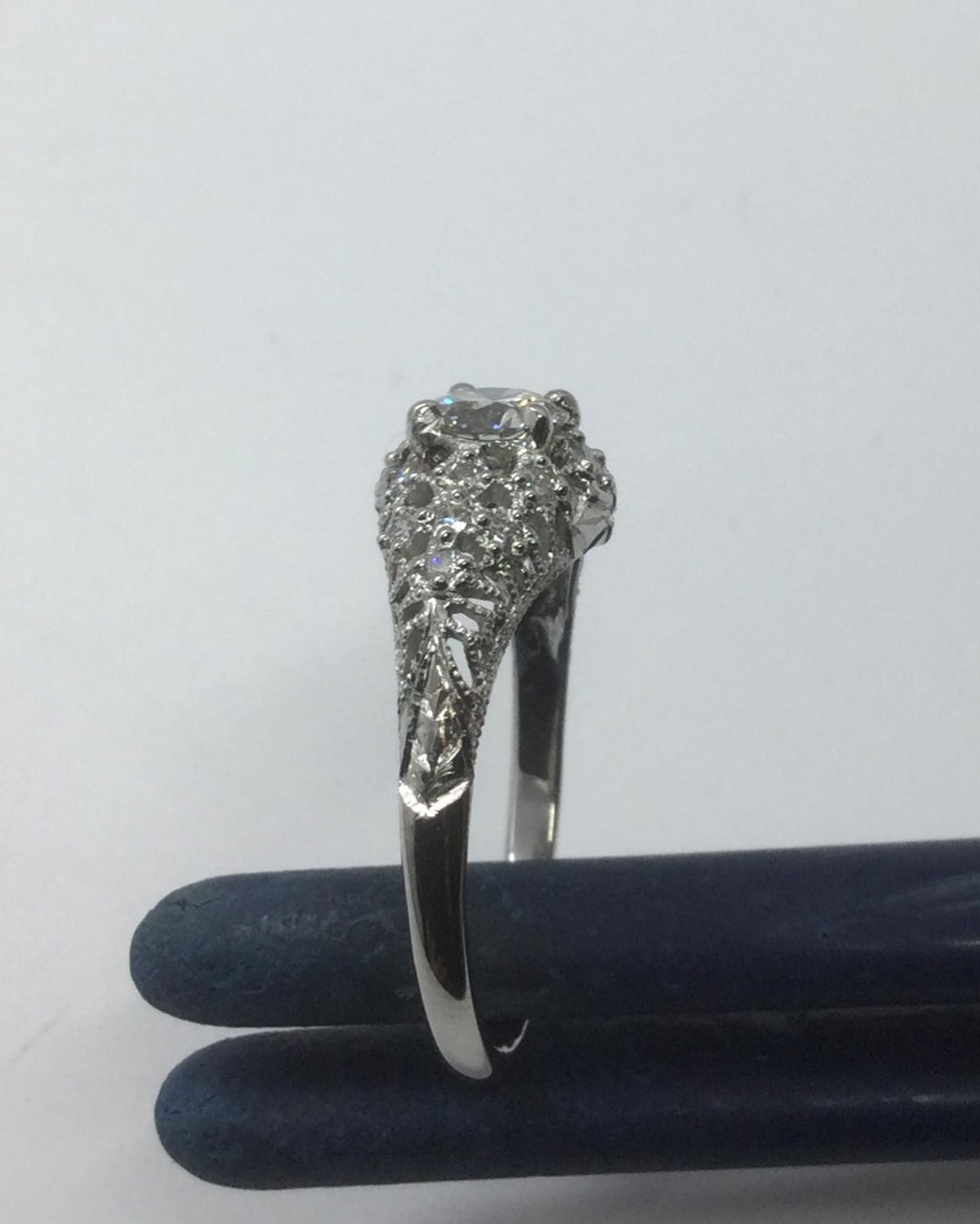 A diamond ring is sitting on a blue cloth