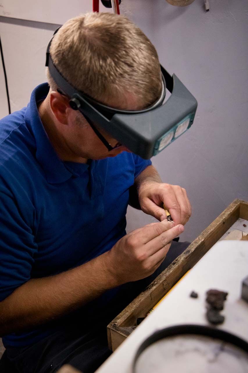 Our jeweler at the bench with magnifying glasses