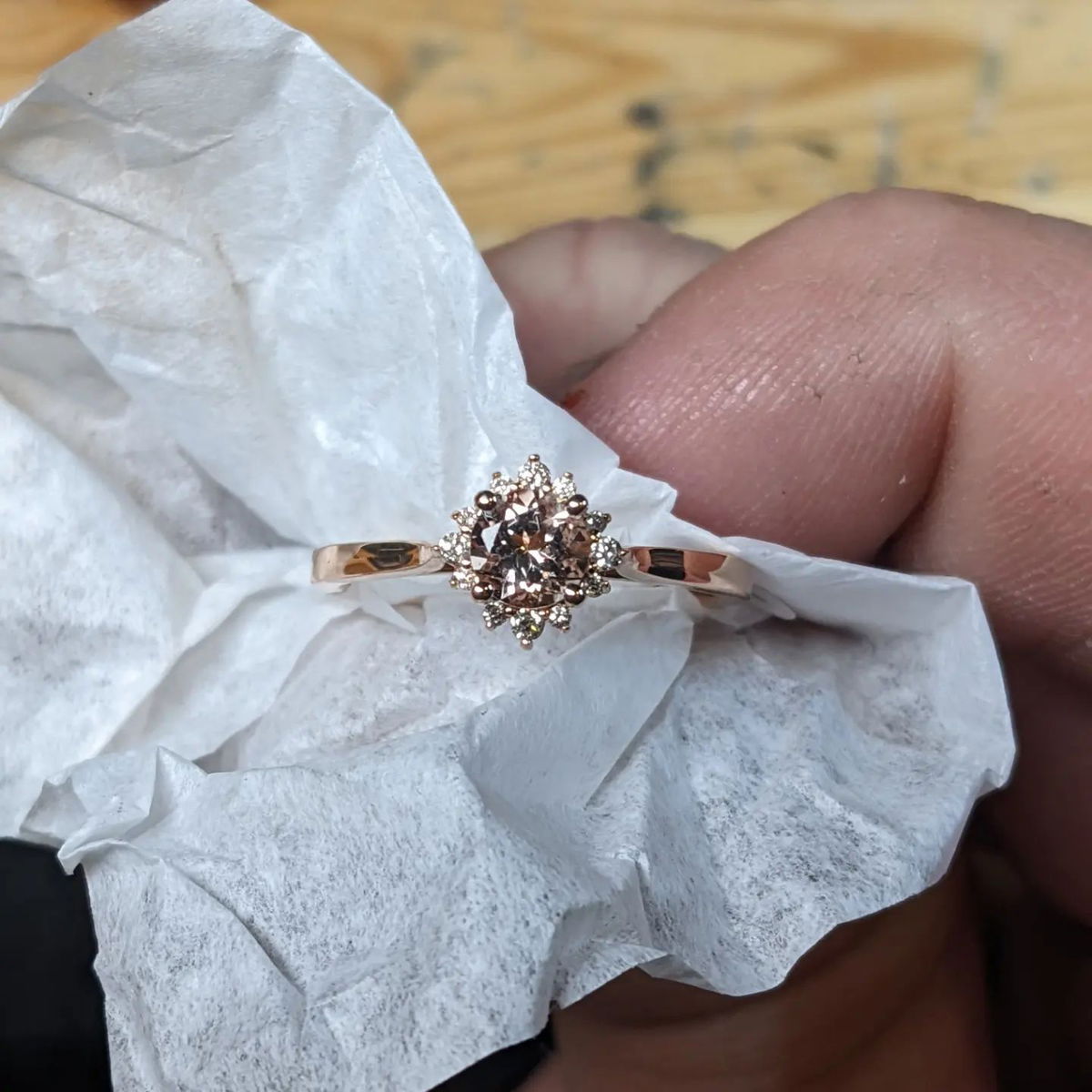 A person is holding a ring on a piece of paper