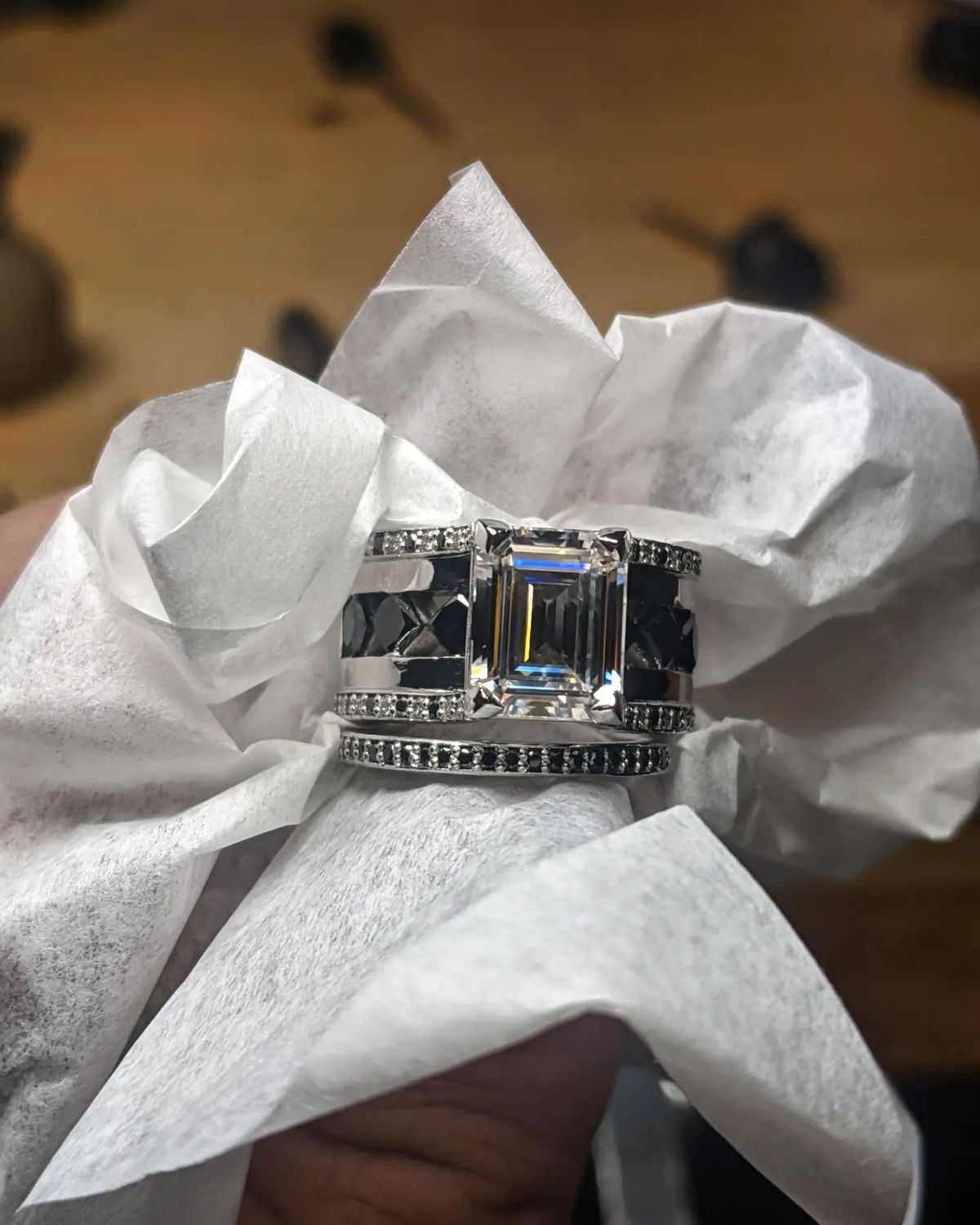 A person is holding a ring on a piece of paper