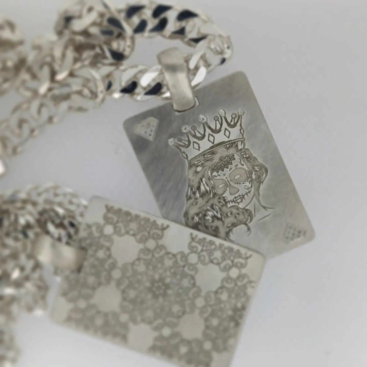 A silver pendant with a picture of a woman wearing a crown