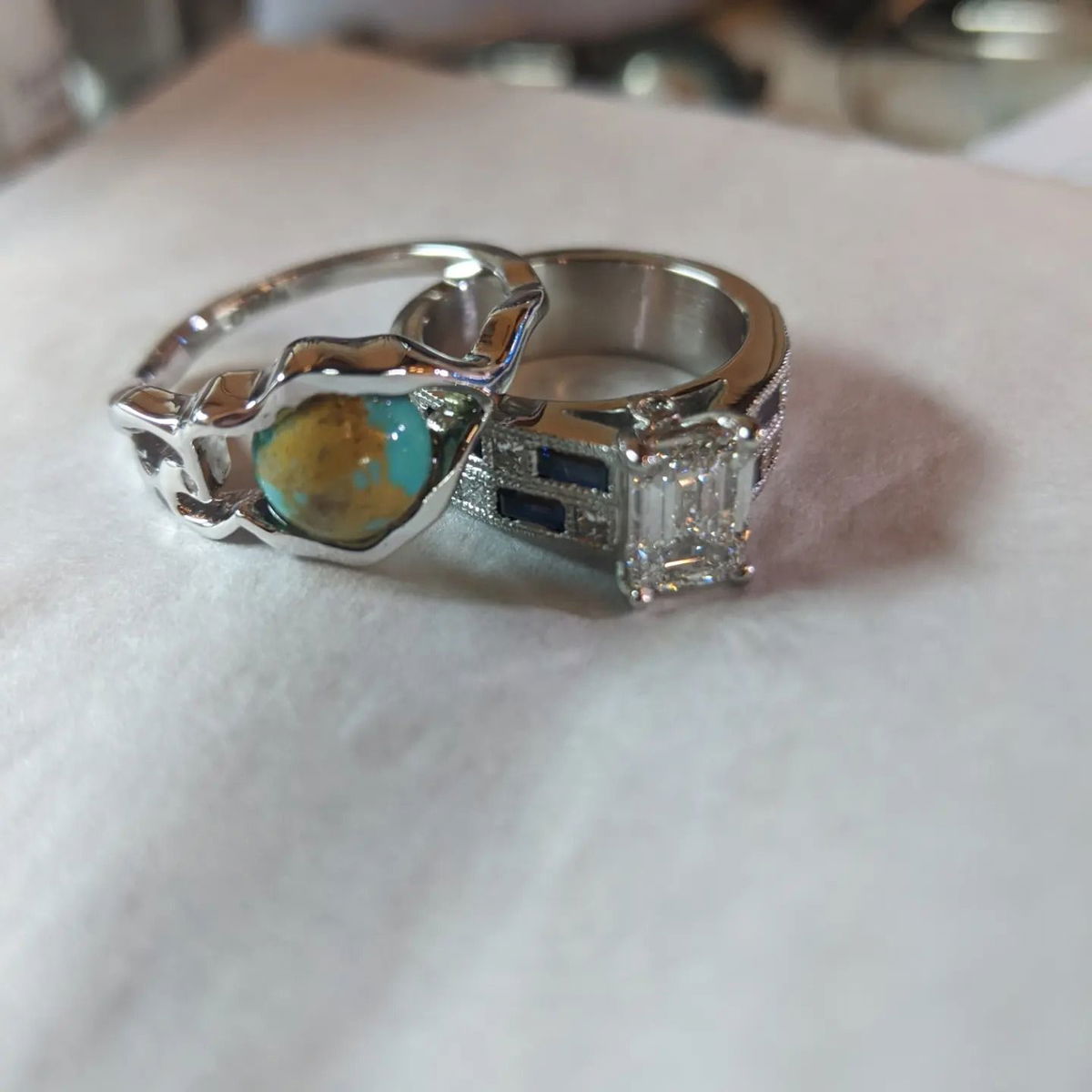 A couple of rings are sitting on a white cloth