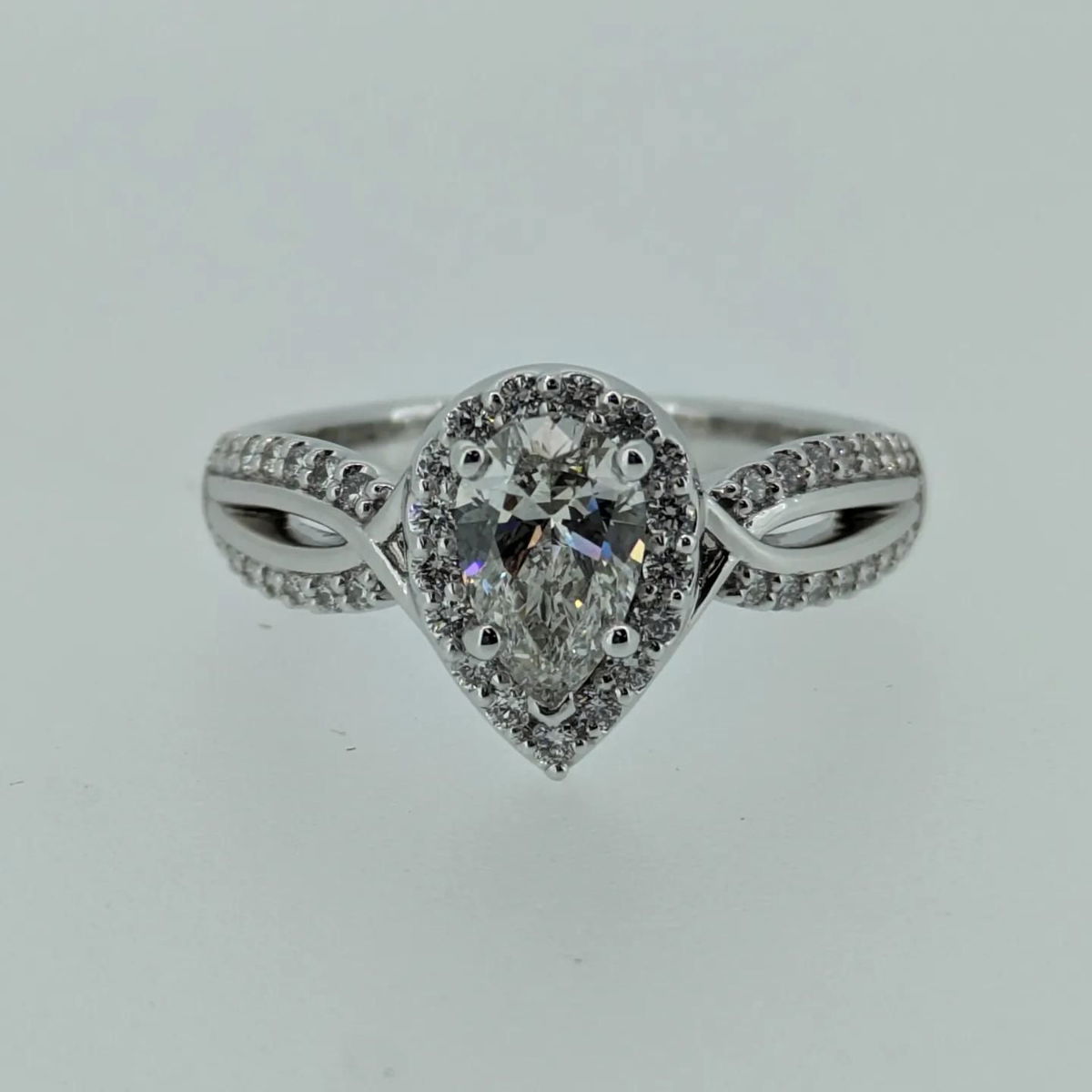 A white gold ring with a pear shaped diamond in the center