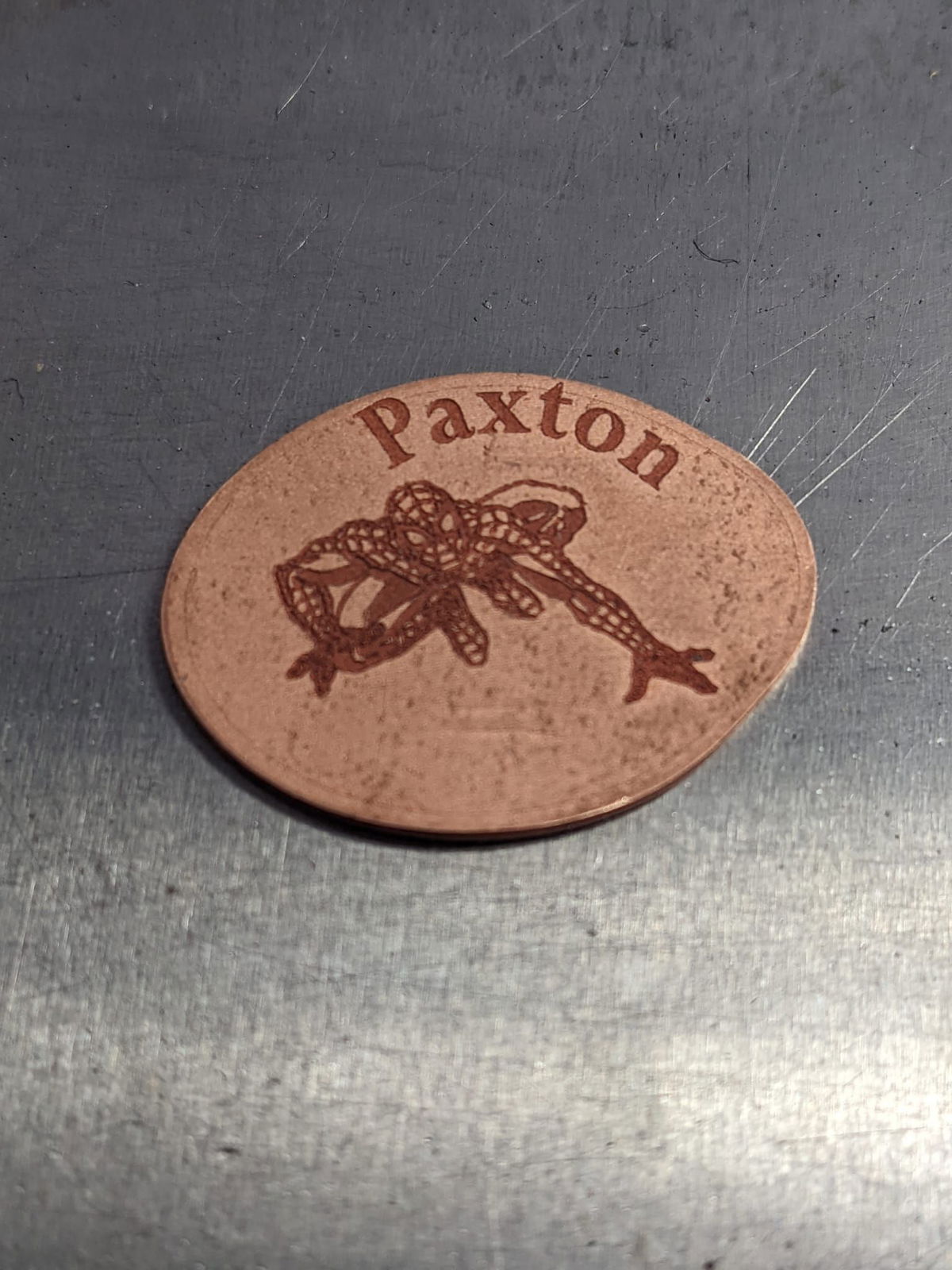 A brown coin with the name paxton on it