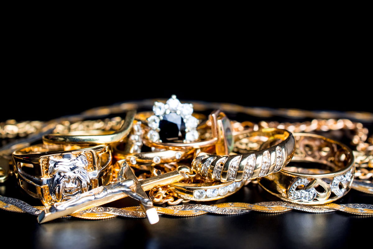 Gold rings and chains on black
