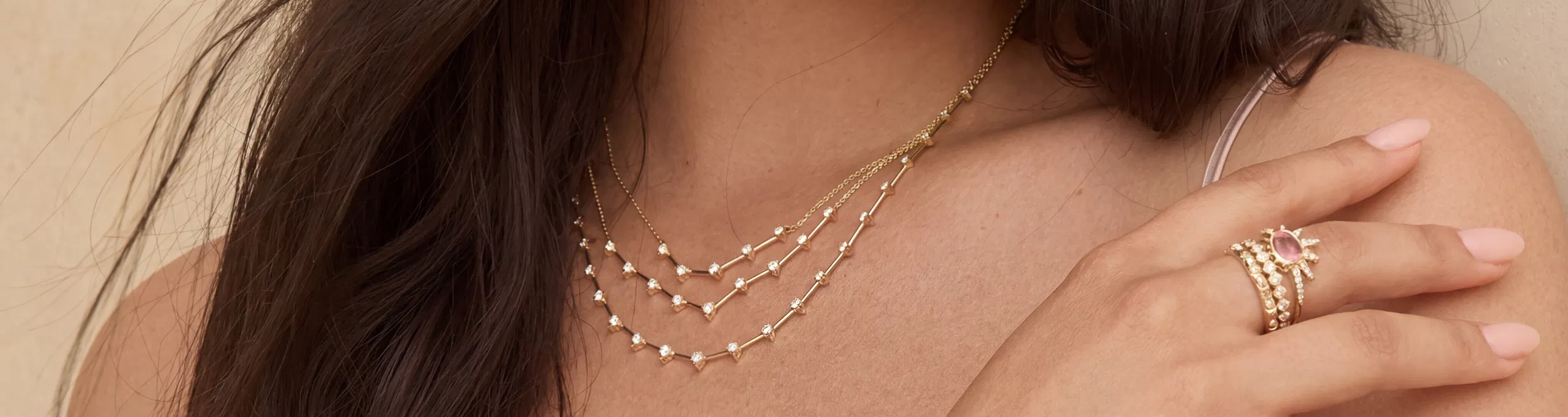 Fine gold pendant and beaded chain necklaces worn and layered elegantly