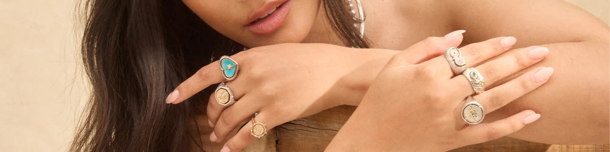 Fine gold necklaces, rings, and charm pendants from Three Stories Jewelry displayed in warm ambient light