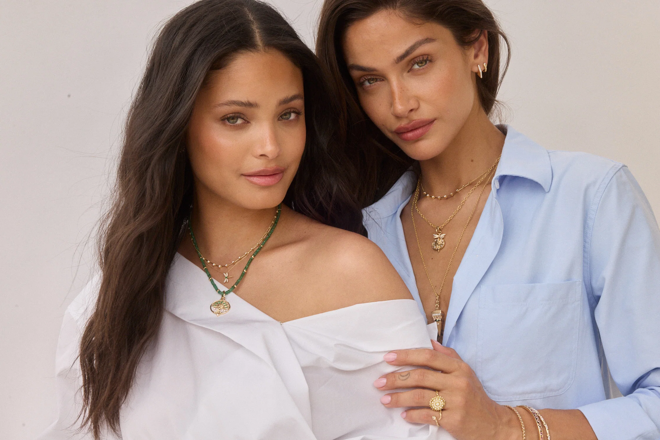 Assortment of hand-crafted 14k gold jewelry with diamond and gemstone accents arranged on linen