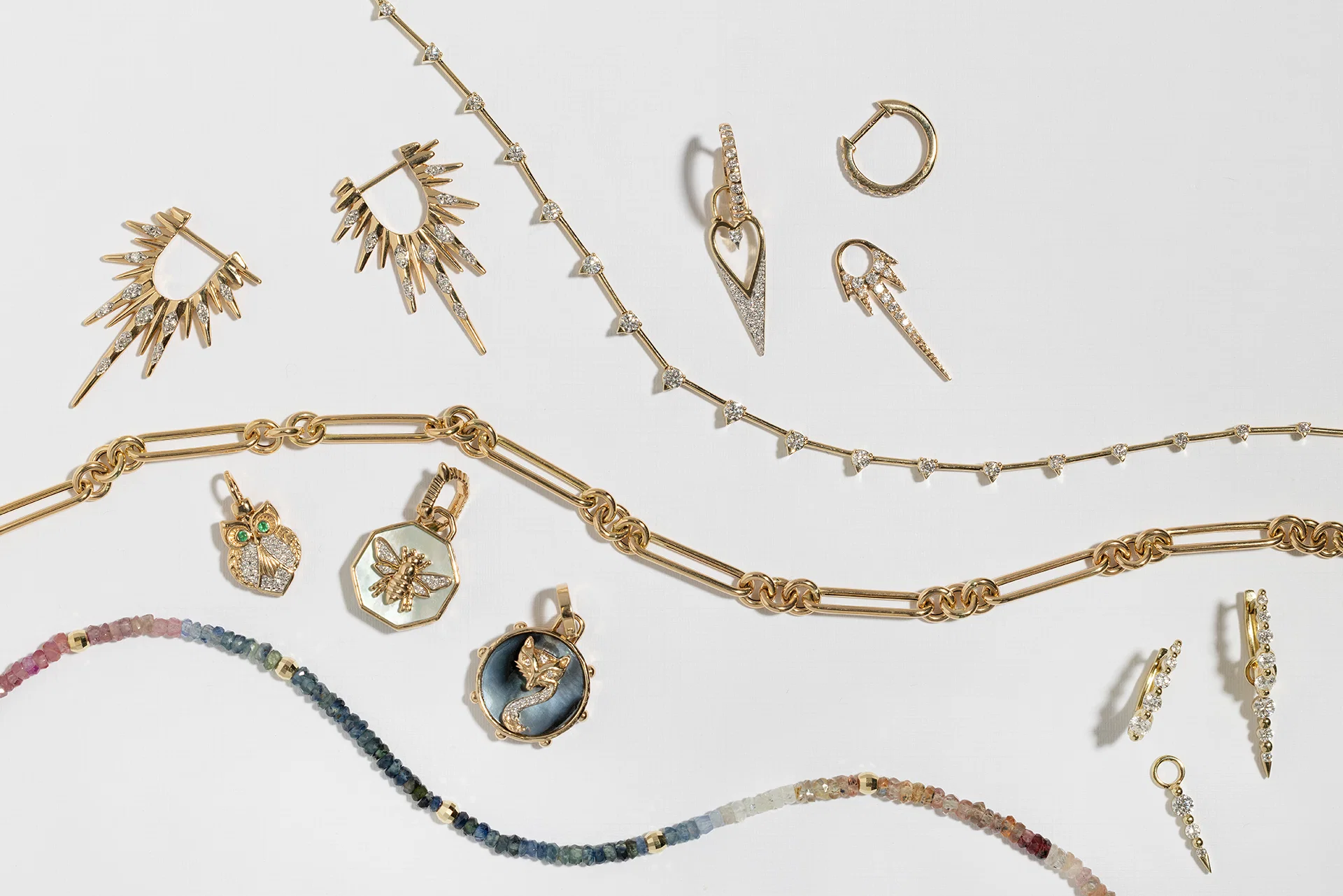 Fine gold and diamond jewelry displayed on a soft neutral surface