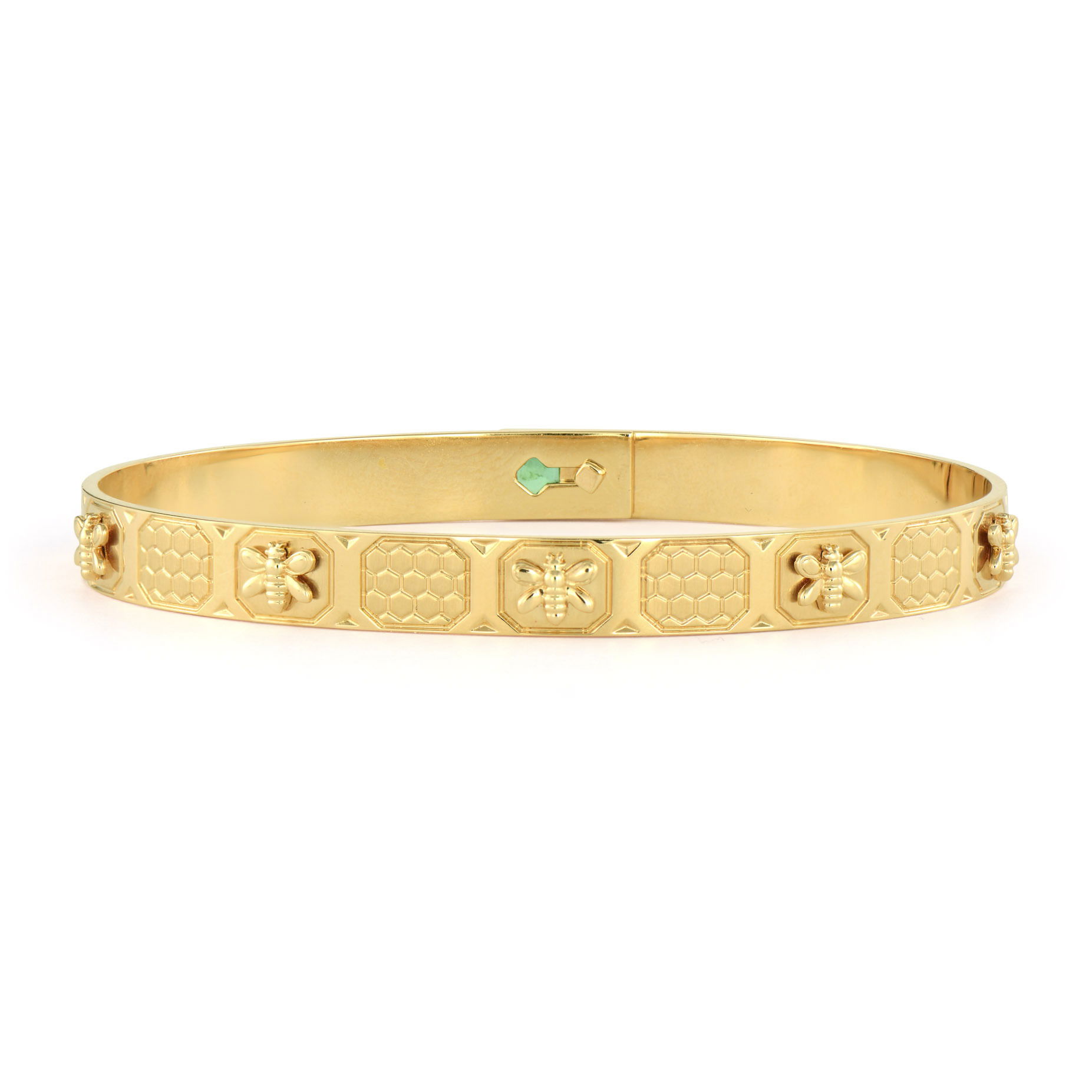 The Queen Bee Eternity Bangle features a nature-inspired design crafted in 14K yellow gold. The surface is meticulously engraved with a continuous honeycomb pattern interspersed with delicate bees, creating a textured effect that celebrates the industrious beauty of the hive. A single bezel-set emerald at the center adds a regal pop of color, symbolizing the queen bee's crown jewel.The flexible design ensures a comfortable fit, while the hidden closure maintains the seamless eternity effect. This meaningful piece represents leadership, community, and the sweet rewards of hard work. The intricate engraving catches the light beautifully, adding both visual interest and symbolic depth. This versatile bangle works beautifully alone or stacked with other bangles for a more dramatic look. Queen Bee Eternity Bangle