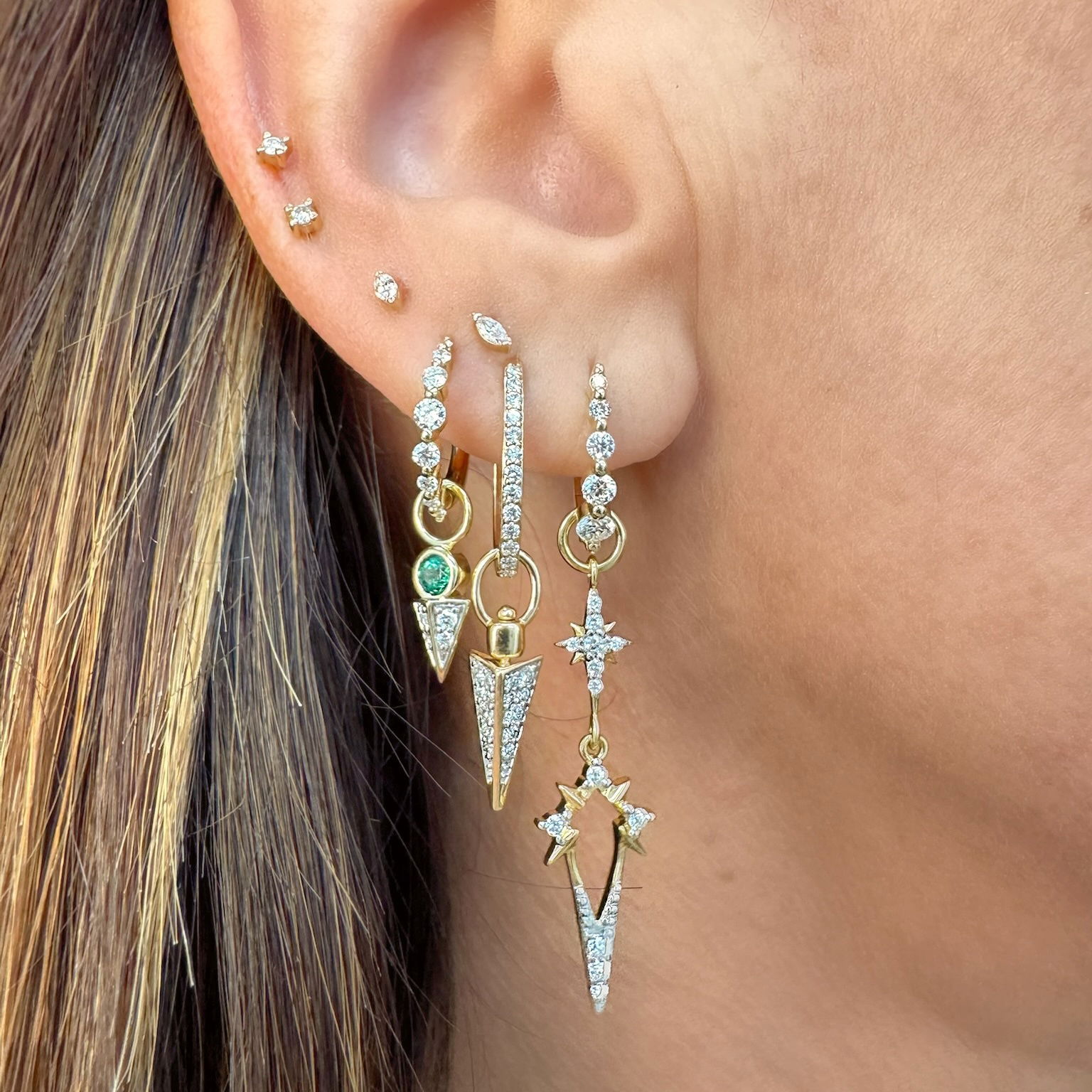 The Double Open Star Charm brings celestial elegance in an elongated design. Crafted in 14K gold, this long charm features two open star motifs adorned with sparkling diamonds that create a constellation effect. The open framework gives the stars an airy, delicate appearance while the diamonds add brilliant sparkle that catches the light beautifully.The elongated silhouette makes this charm a striking addition to any jewelry collection, perfect for those who love to make a statement. This sparkling gold charm can be worn on Three Stories hoop earrings or added to a chain bracelet or necklace by adding an openable pendant bale. Charms sold as singles. Hoops and charms sold separately. Double Open Star Charm