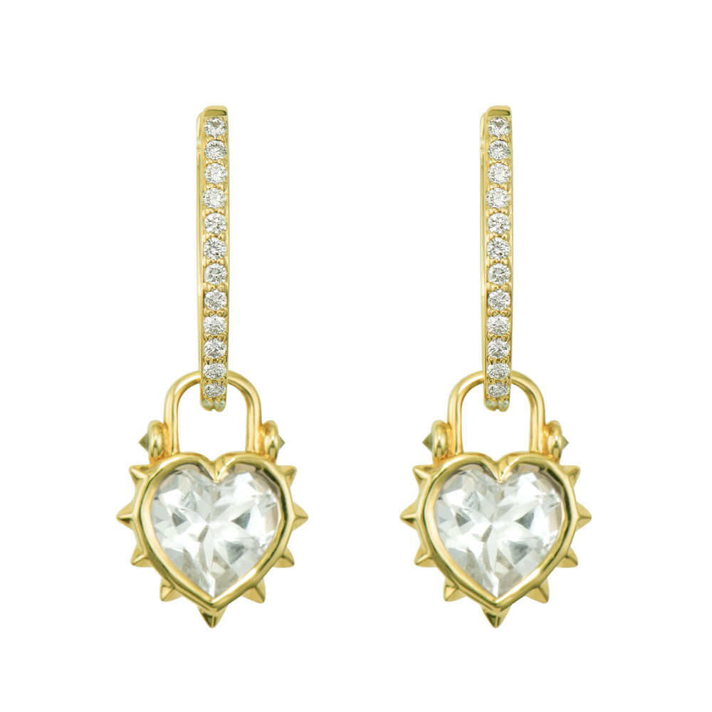 This Thorned Jewel Heart Charm features a striking contrast between delicate and edgy elements. Crafted in 14K yellow gold, the centerpiece is a heart-shaped white topaz, beautifully secured in a bezel setting. Surrounding this clear gem are thorny spikes that give this charm its distinctive character, with a few diamonds adding unexpected sparkle among the thorns. The juxtaposition of the smooth, elegant topaz against the protective thorns creates a meaningful statement piece. This sparkling gold charm can be worn on Three Stories hoop earrings or added to a chain bracelet or necklace by adding an openable pendant bale. Hoops and charms sold separately. Thorned Jewel Heart Charm
