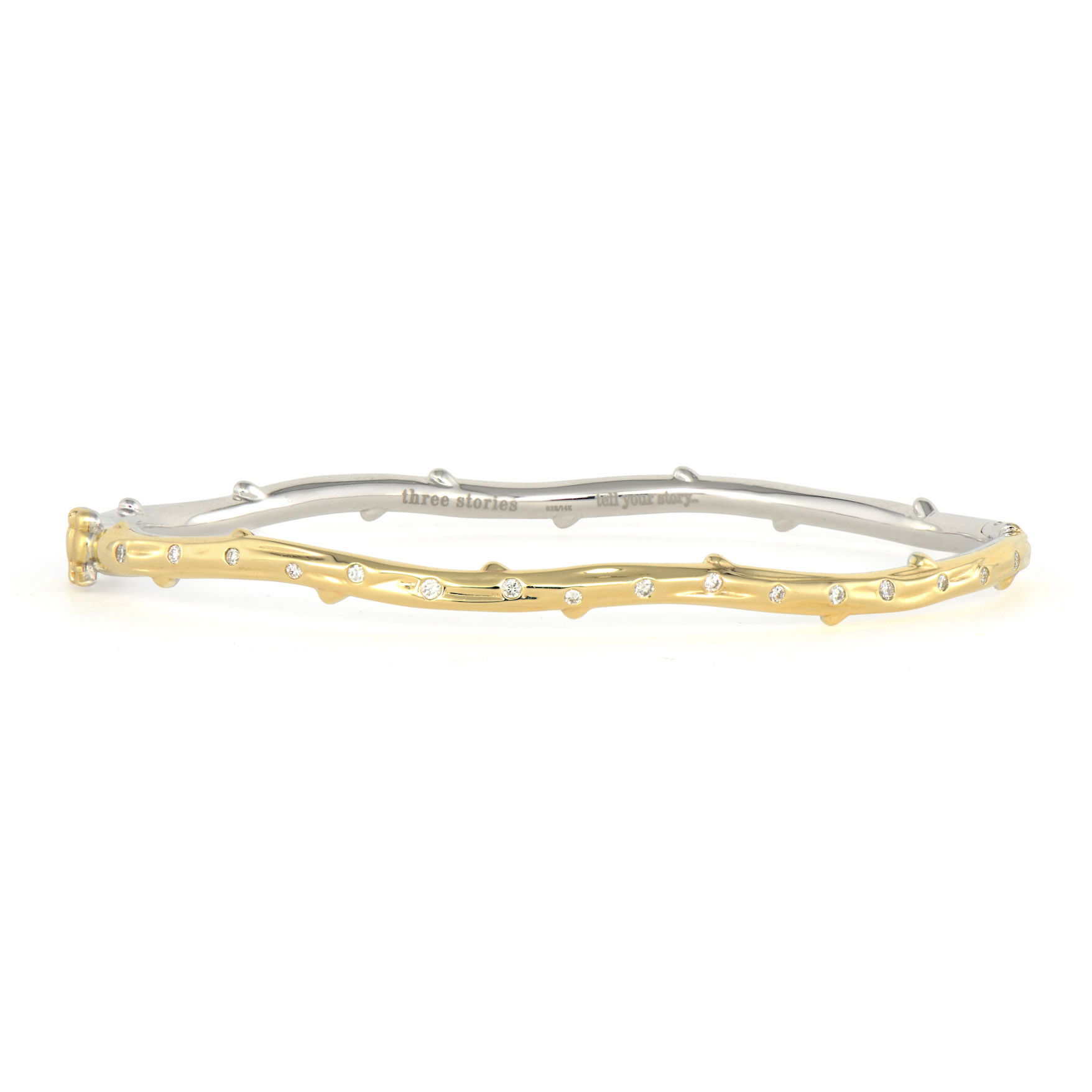 The Two-Toned Tree of Life Bangle brings meaningful symbolism to your wrist in sophisticated style. Crafted in sterling silver and 14K gold, this elegant piece features an intricate branch design that represents growth, connection, and renewal. Sparkling diamonds are nestled throughout the branches, adding brilliant accents that catch the light like morning dew.The two-toned metals create beautiful contrast while the organic branch pattern flows naturally around your wrist. The clasp features two love birds, adding a romantic touch to this symbolic piece. This meaningful bangle celebrates life's interconnectedness and personal growth, making it perfect for those who appreciate jewelry with deeper meaning. Wear alone or in a Three Stories bangle stack. Two-Toned Tree of Life Bangle