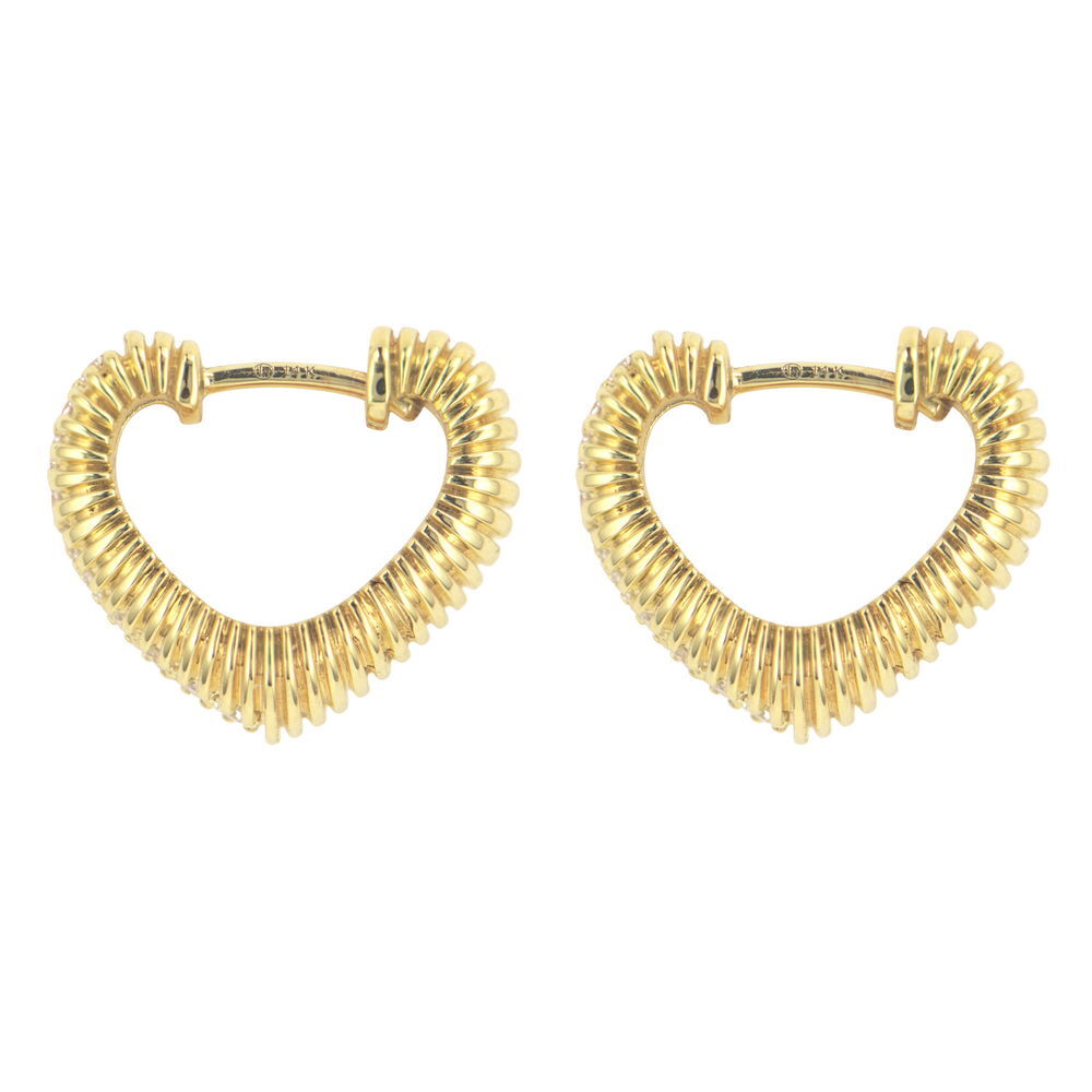 The Puffy Ruffled Heart Hoop brings romantic texture to your ear styling. Crafted in 14K gold, this huggie-style hoop features a distinctive puffy heart design with beautiful ruffled detailing that creates dimension and visual interest. Sparkling diamonds adorn the textured surface, catching the light beautifully.The combination of the soft, romantic heart shape with the intricate ruffled texture creates a piece that's both sweet and sophisticated. The huggie style ensures comfortable, secure wear while the puffy design adds striking detail that sets this hoop apart from traditional styles. Perfect for adding a touch of textured romance to your jewelry collection. Hoops sold as singles. Puffy Ruffled Heart Hoop