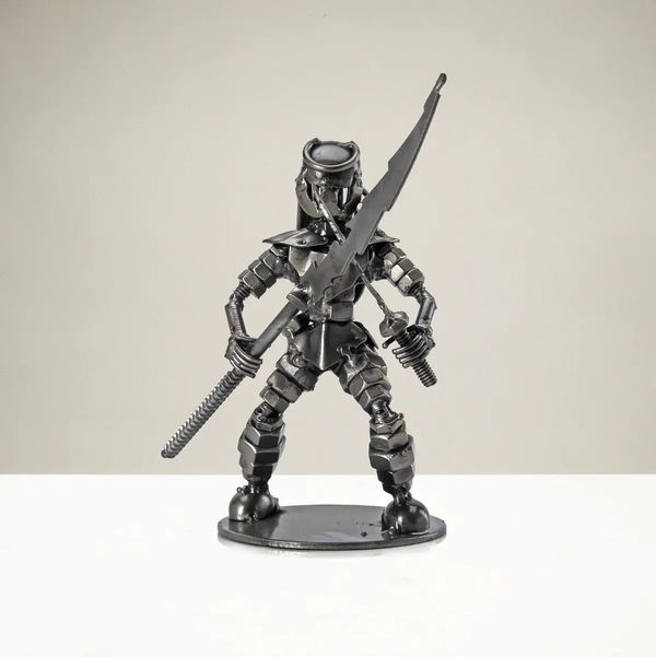 Closeup photo of Dual Wielding Predator with Spear Inspired Recycled Metal Sculpture