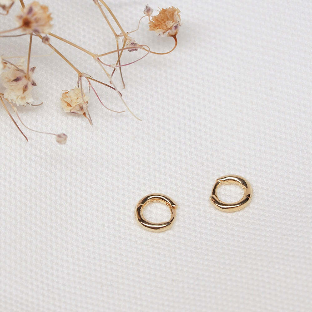 Our Mini Huggie Hoop is the most perfect, teeny tiny hoop for any placement on your ears. It's always a good time to upgrade your staple earrings to 14k gold. Material: 14K Solid Yellow GoldOuter Diameter: 6.8mmThickness: 1.2mmHoops Sold Individually AURELIE GI GIA | Single Mini Huggie Hoop