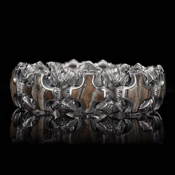 Want to make your own history by wearing it? The 'Aleksius' features heavy sculpted sterling silver links inlaid with 10,000 year-old fossil Woolly Mammoth tooth, the last remaining legacy of a legendary creature that walked the earth at the dawn of civilization. Found on the seafloor and brought to the light after thousands of years, each tooth is unique, so every piece we cut and inlay is unique and tells its own story. Finished with our stainless button lock clasp inlaid with a genuine diamond. Aleksius Mammoth Tooth Bracelet