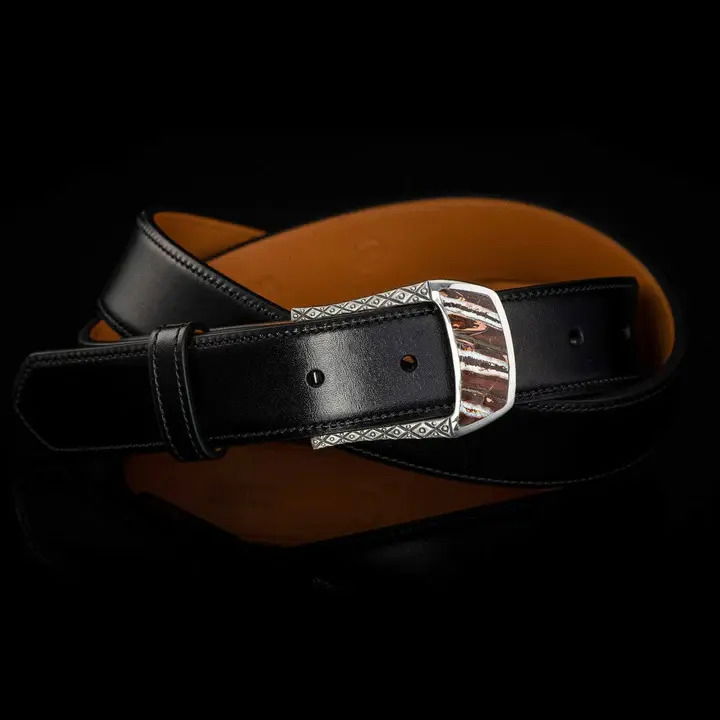 This beautiful belt buckle works from the street to the boardroom, and it creates an elegant accent to any attire. Sculpted in solid sterling silver, the highlight is an amazing inlay of Wooly Mammoth Tooth. Each inlay is hand-polished from a slice of the molar tooth of the Wooly Mammoth, the legendary creature that roamed Earth from 6000-10000 years ago. Fits any 1.25” (1 and ¼” wide) belt that allows for interchanging buckles. BUCKLE 3 - MAMMOTH
