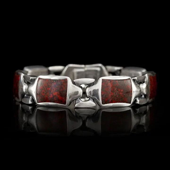 A classic from the first pencil drawing on a napkin! The Retro sets an unparalleled standard on the wrist. Simple and timeless elegance in a bracelet that wears with anything, for any occasion. Offered here in sterling silver with our 'leaf' pattern, inlaid with fossil dinosaur bone. Features our precision stainless steel button lock closure with inset smoky quartz gemstone. Dino Bone Retro Bracelet