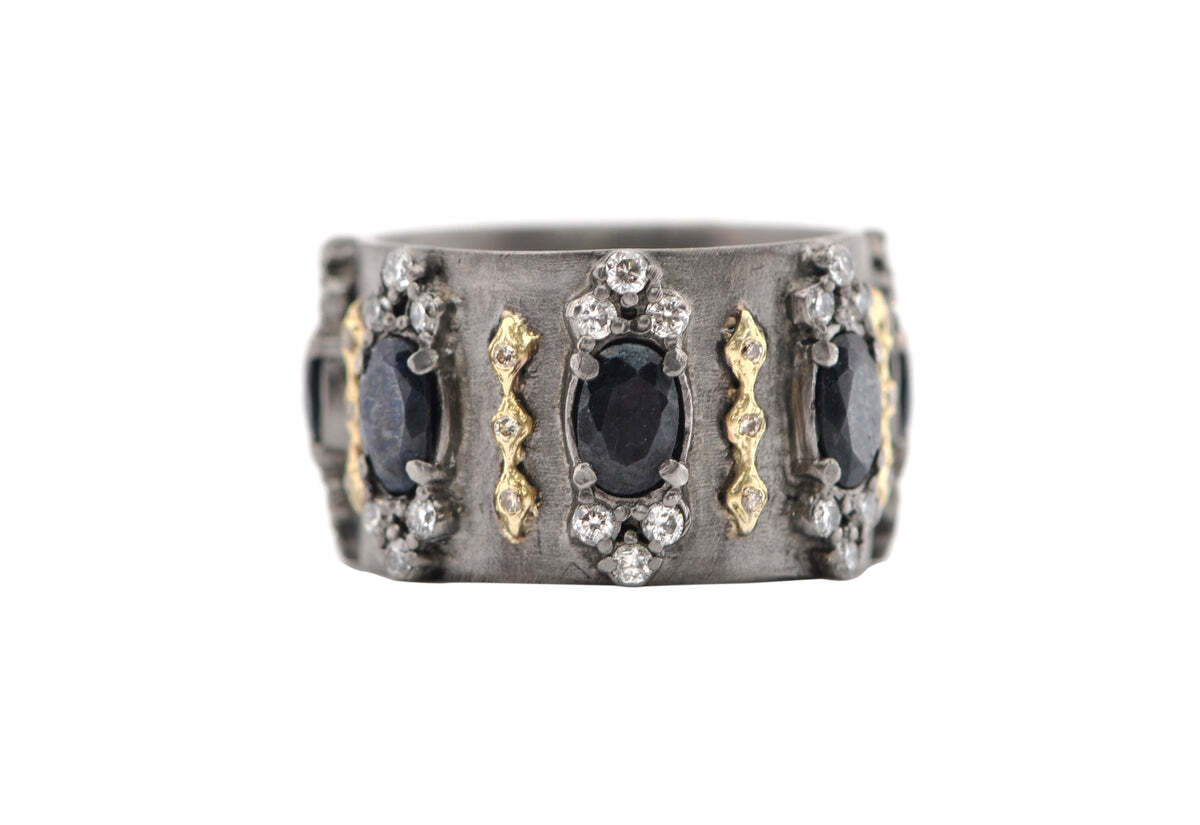 This stunning 18K Yellow Gold and Blackened Sterling Silver Wide Band Ring with Black Sapphires, White Diamonds and Champagne Diamonds is sure to turn heads. Boasting 0.89 TCW of diamonds, this piece is perfect for anyone looking to make a statement with their jewelry. The ring's unique and enchanting design features a wide blackened sterling silver band, three rows of beautiful black sapphires, two rows of sparkling white diamonds, and one row of warm champagne diamonds. Whether worn as a fashion statement or an everlasting romantic symbol, this ring is an absolute must-have. Wide Band Ring