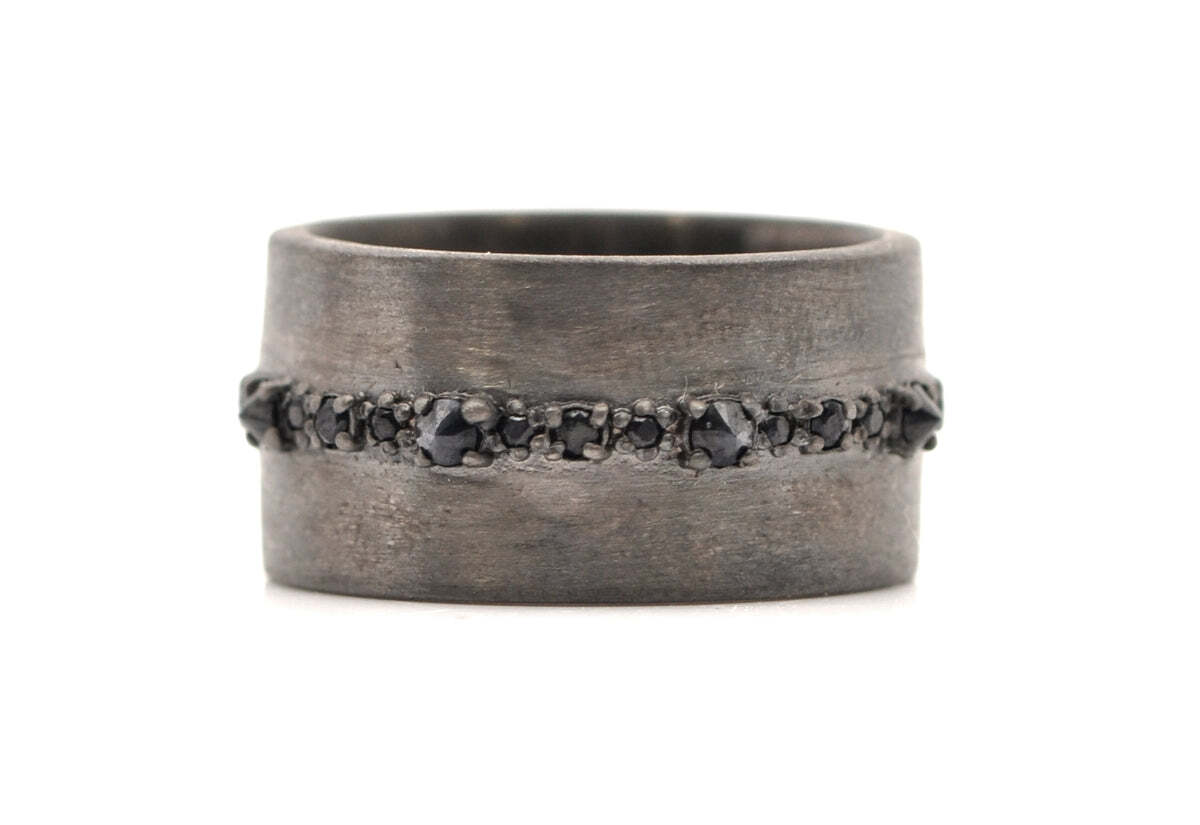 Spice up your wardrobe with this bold and beautiful Blackened Rhodium Finish Sterling Silver wide band. Crafted with meticulous detail, this ring has alternating spiked and pave set black sapphires around the center that add a stunning effect. The impressive ring band measures 9.1mm wide, making it a perfect statement piece that will bring out your unique style. With a bold look and an eye-catching shine, this ring is perfect for any fashionista. BLACK SAPPHIRE SPIKED HORIZON RING